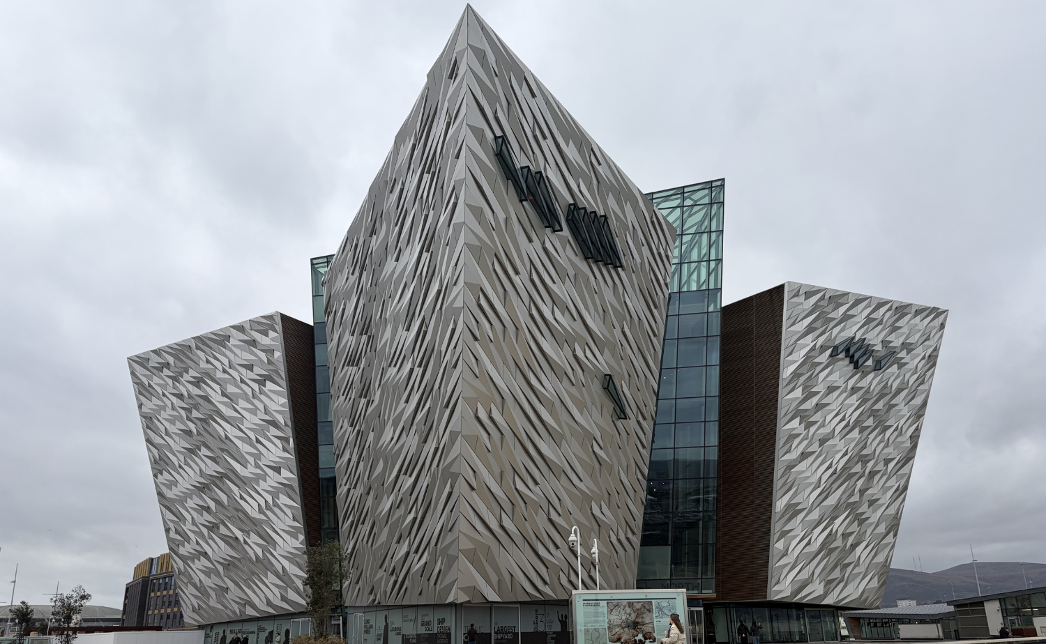The striking angular exterior of Titanic Belfast museum in Belfast, Northern Ireland, designed to resemble ship prows and reflecting the city’s shipbuilding heritage.