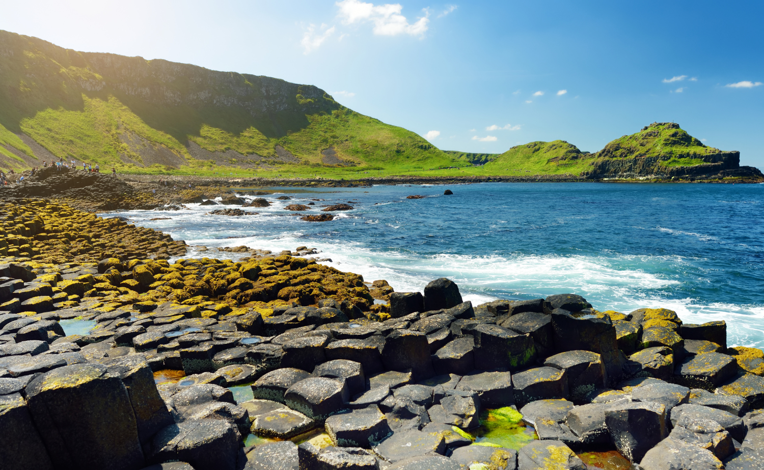Basalt stone columns along the Giant’s Causeway coastline in Northern Ireland with ocean views.