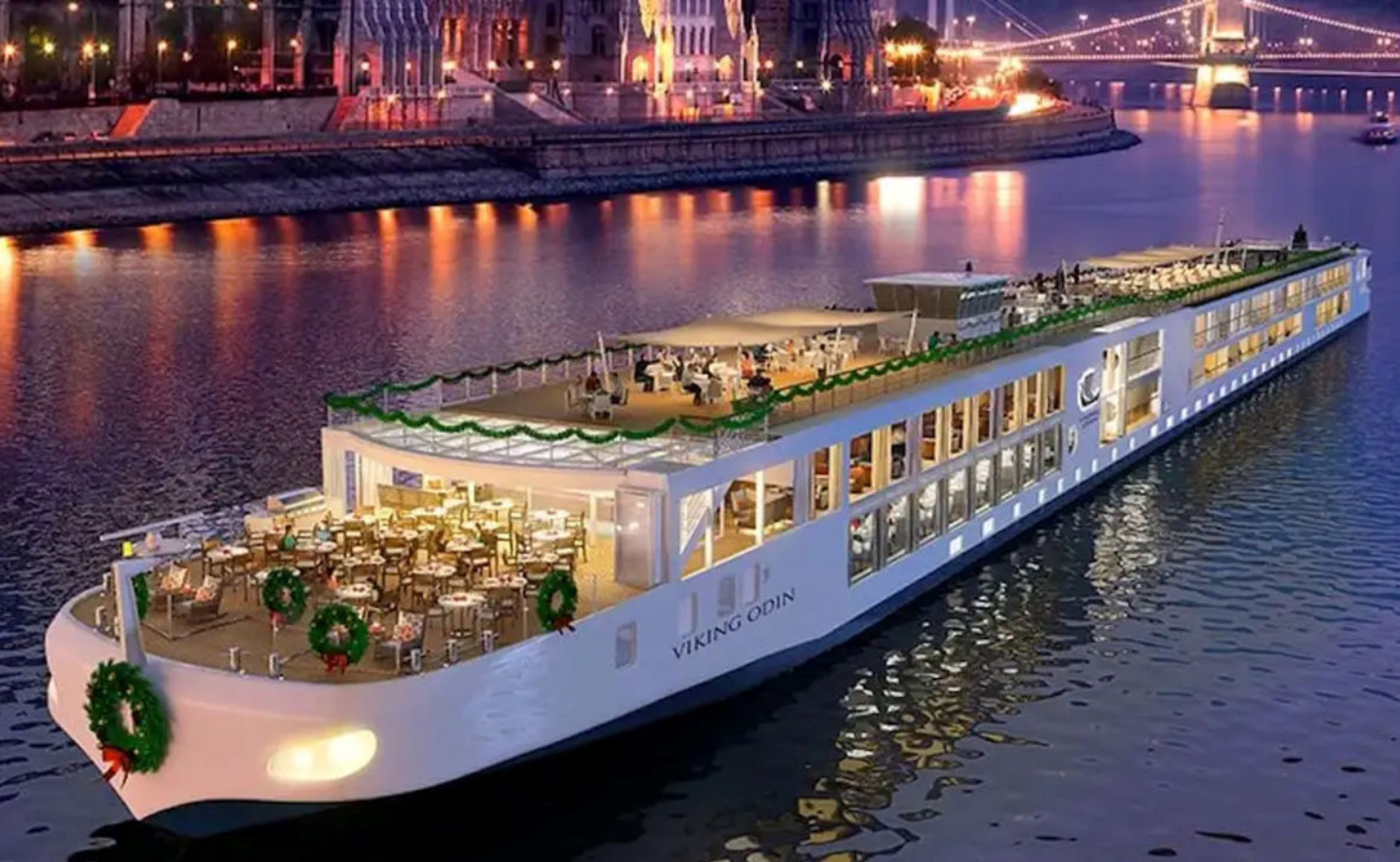 A Viking River Cruises ship decorated with Christmas wreaths and festive lights while sailing through Europe during the holiday season