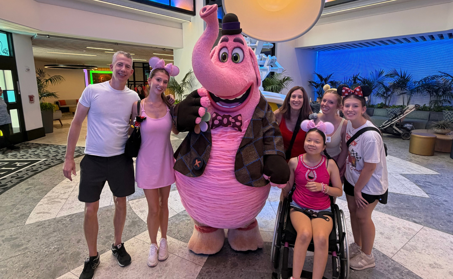 Hannah in her wheelchair with her family during a Disney character experience at Disneyland Resort.