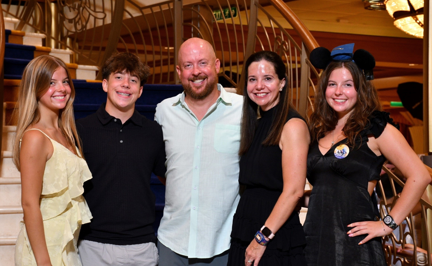 A family dressed for dinner aboard Disney Cruise Line during a graduation celebration cruise.