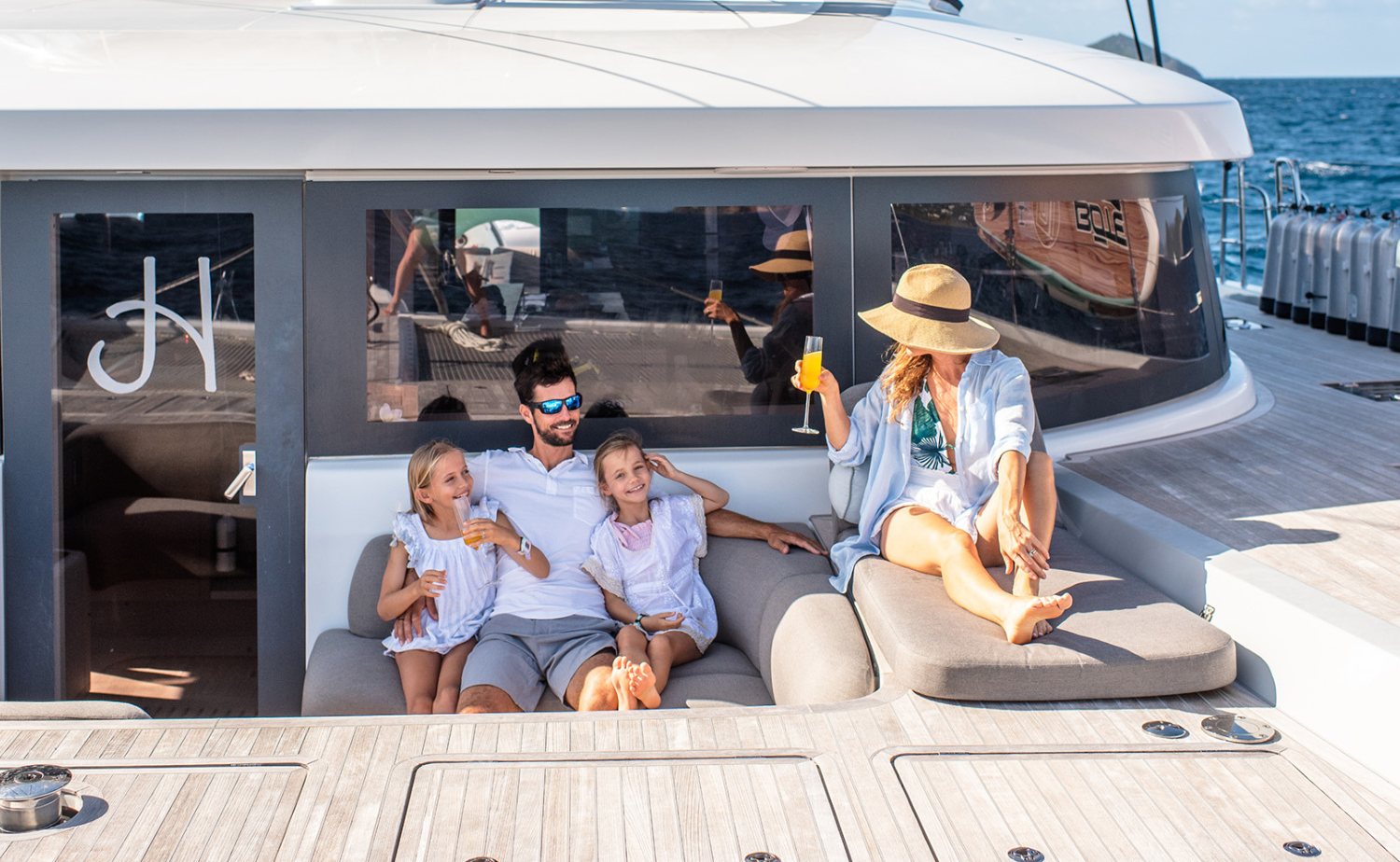 Family relaxing aboard a private luxury yacht in the U.S. Virgin Islands surrounded by calm blue water.