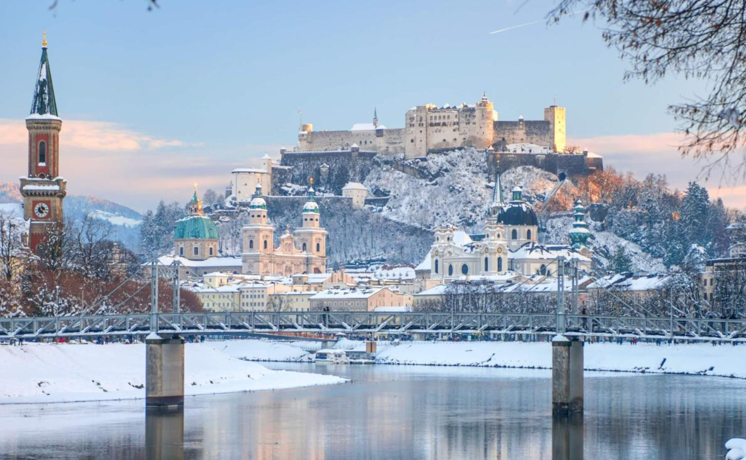 Snow-covered Salzburg, Austria overlooking the Salzach River with its historic fortress and baroque skyline during winter