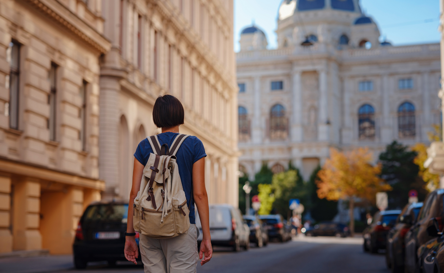 A solo traveler walking through a historic European city with a backpack while exploring independently.