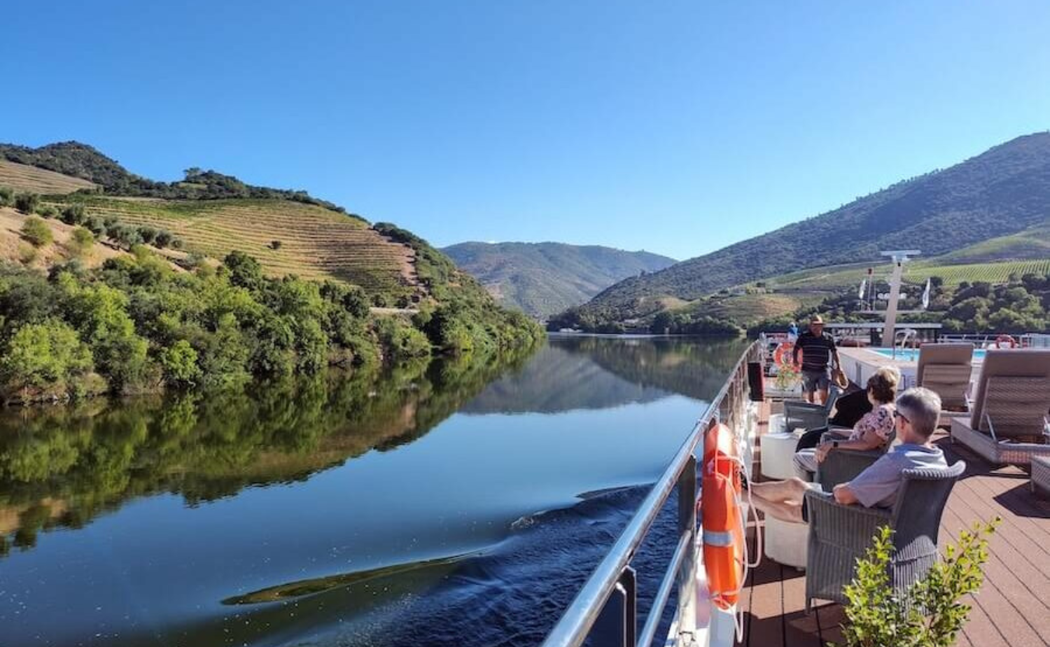 Guests enjoying scenic views from a river cruise ship sailing through Portugal's Douro Valley