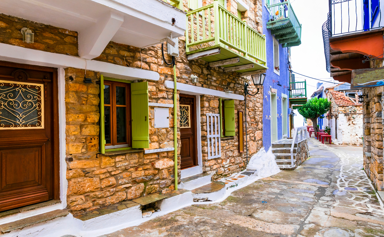 Traditional stone homes with colorful shutters along a narrow village street on Alonissos in the Sporades