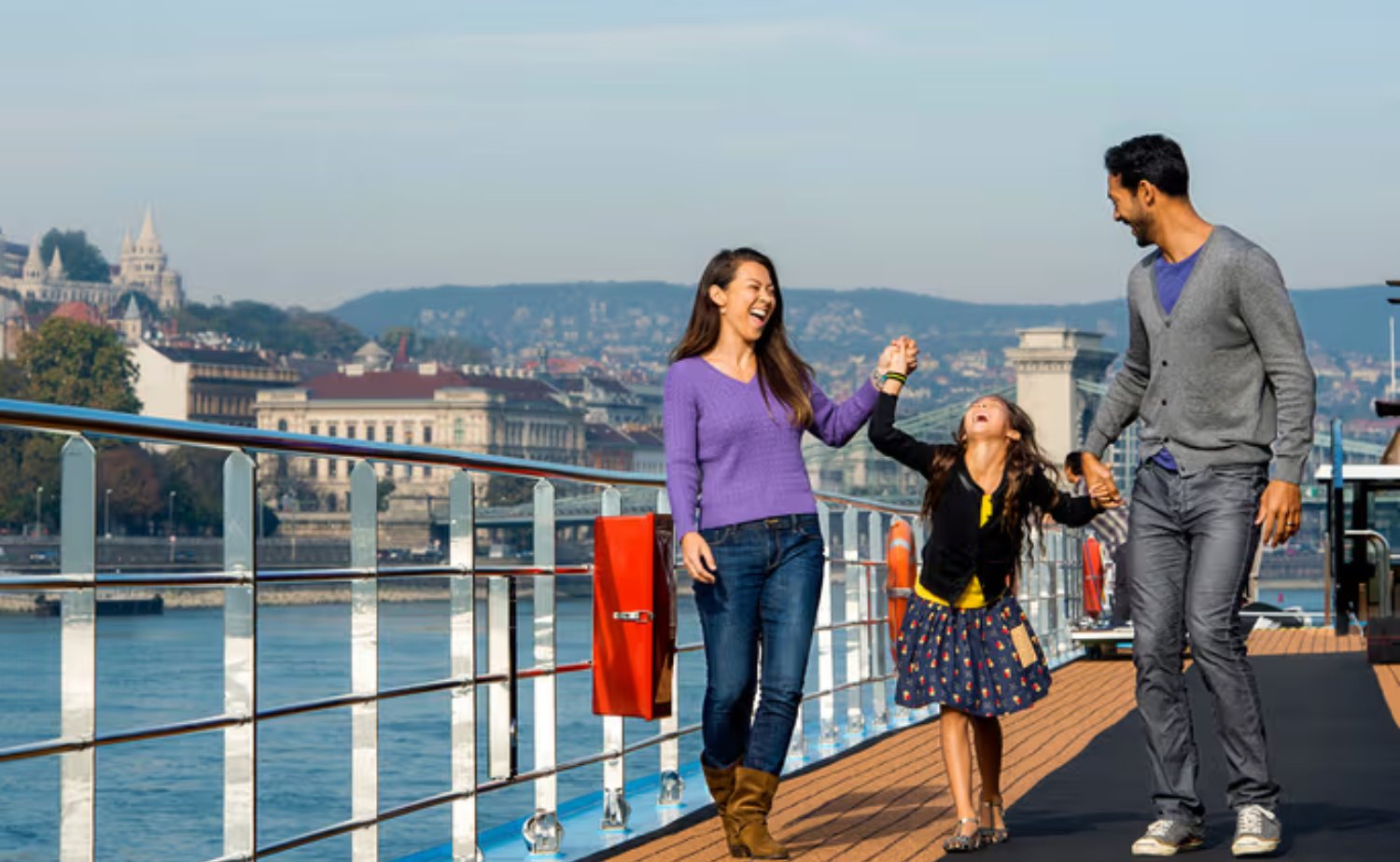 Family enjoying time together on the sun deck of a European river cruise while sailing through Budapest