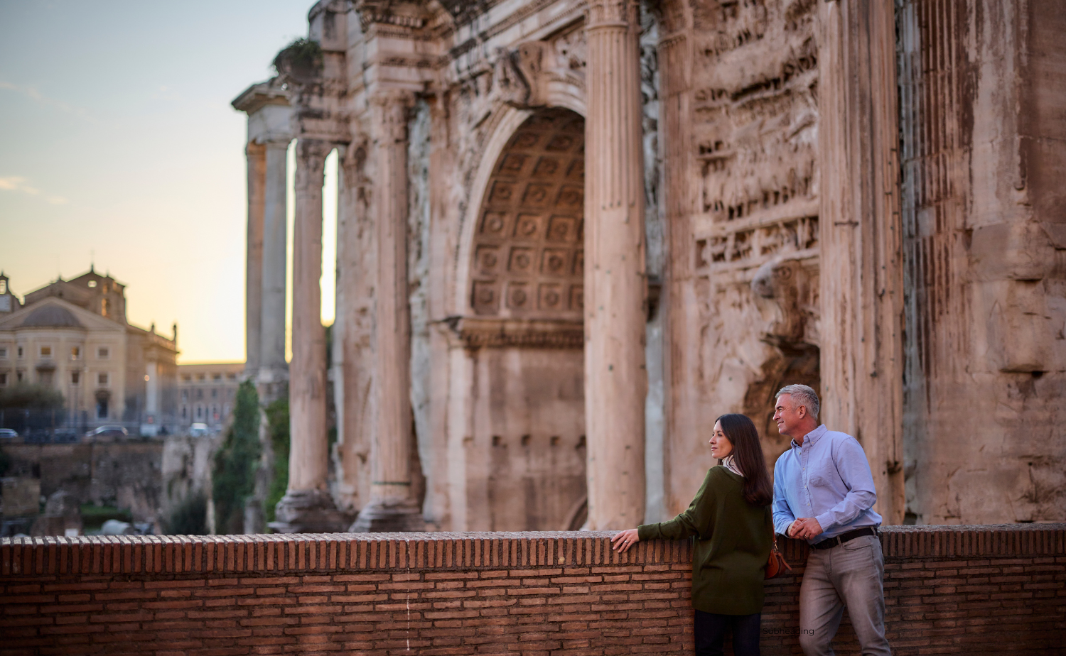 A couple stands together overlooking ancient ruins during a private shore excursion in Rome.