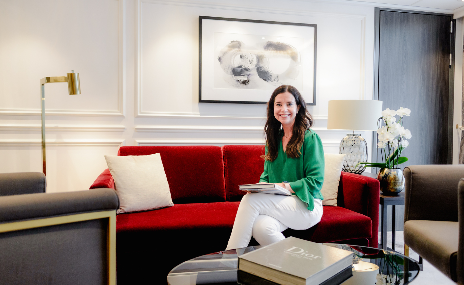 Laura Legg sitting in an elegant luxury river cruise suite while planning custom travel experiences for clients in every season of life.