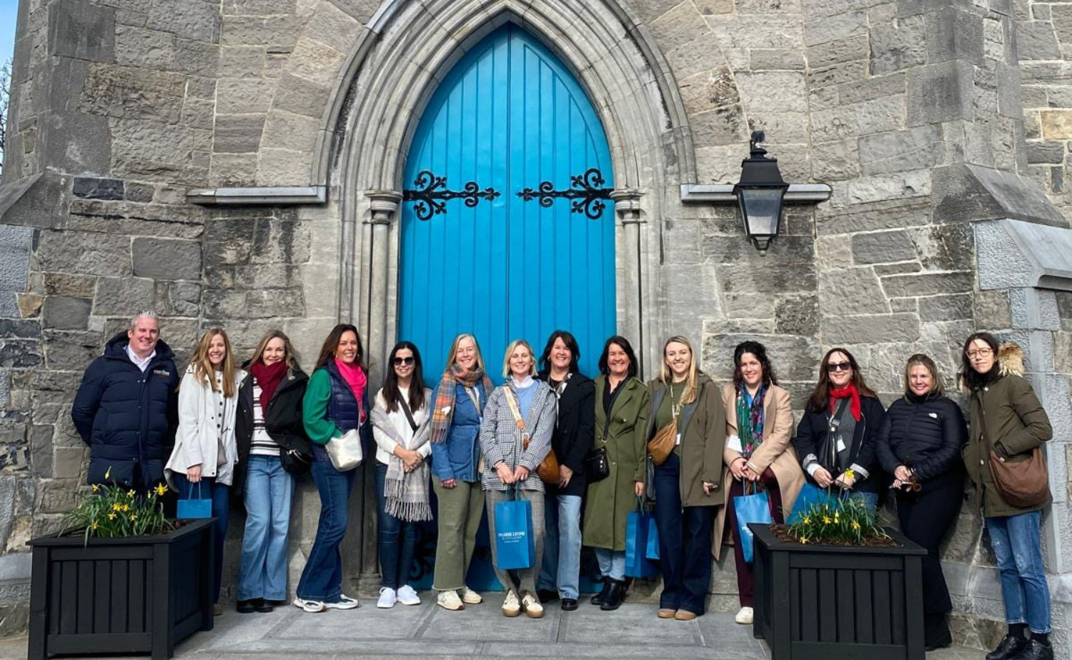 A group of travelers poses outside Pearse Lyons Distillery in Dublin, highlighting the shared experiences and cultural stops that make guided group travel in Ireland so memorable.