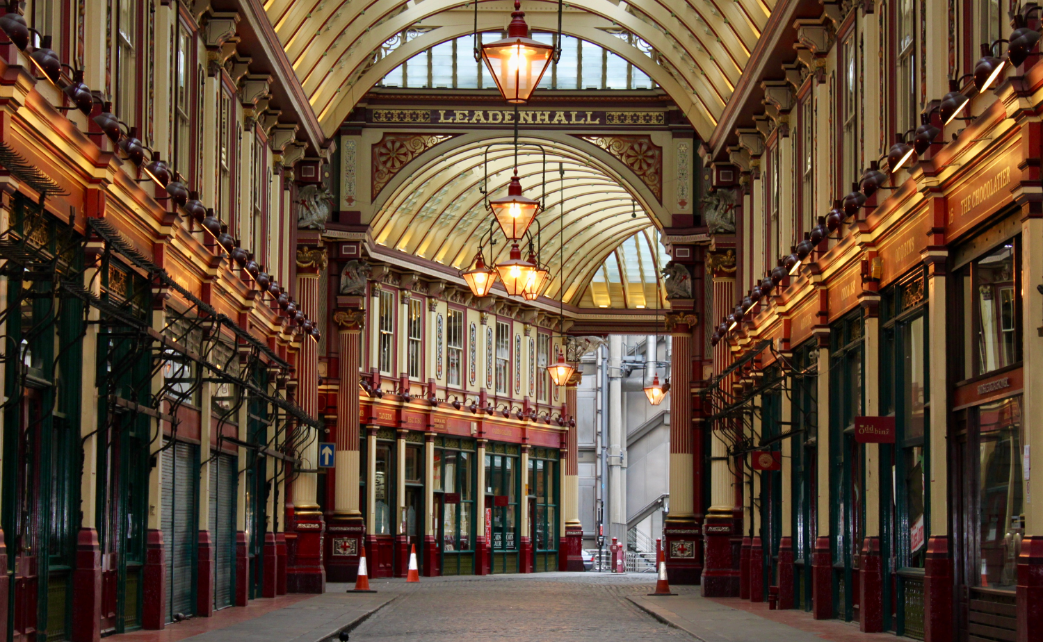 Interior of Leadenhall Market in London with its ornate Victorian architecture and arched glass roof.