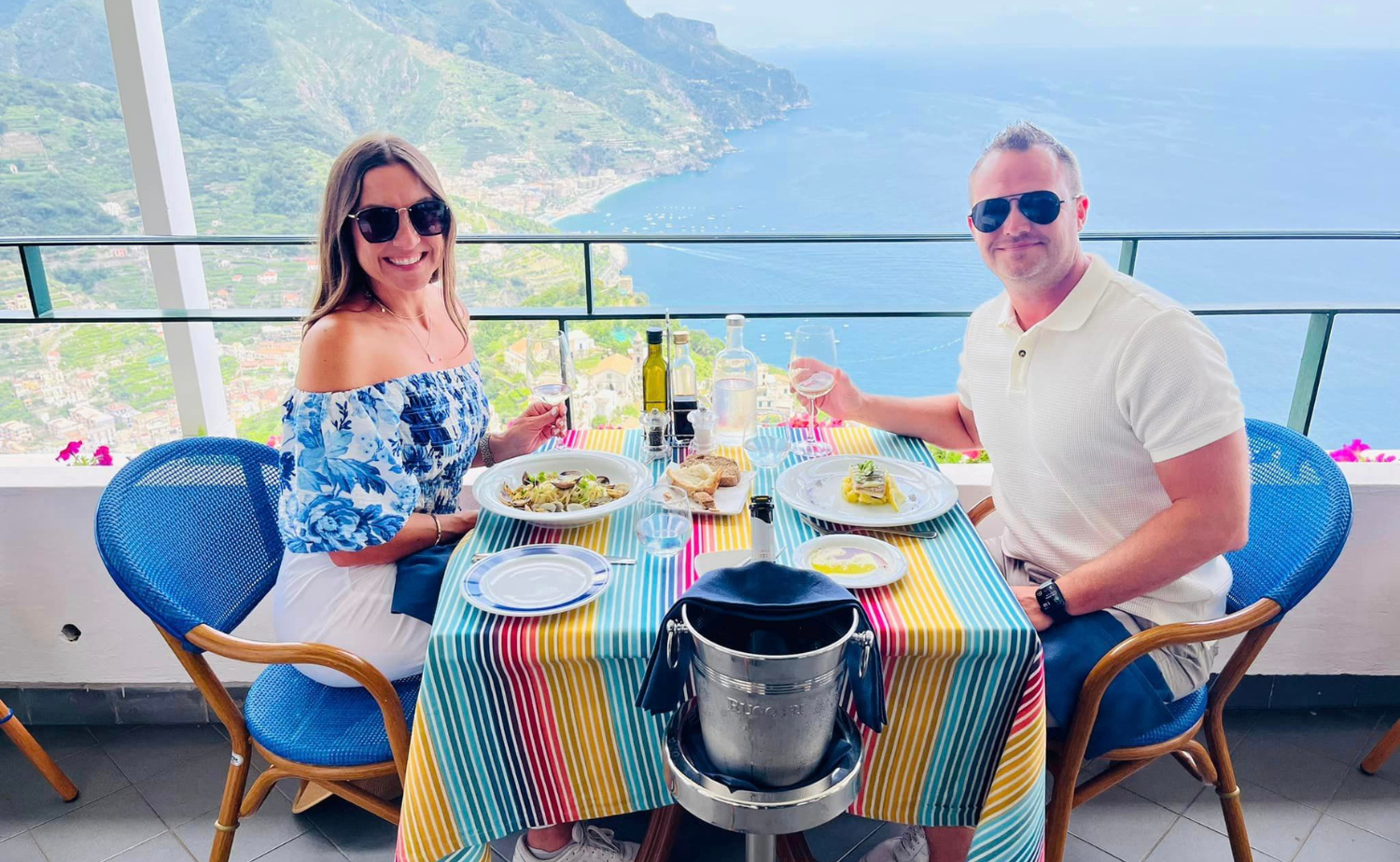 Castaway Destinations clients enjoying a terrace lunch with panoramic views of the Amalfi Coast, Italy