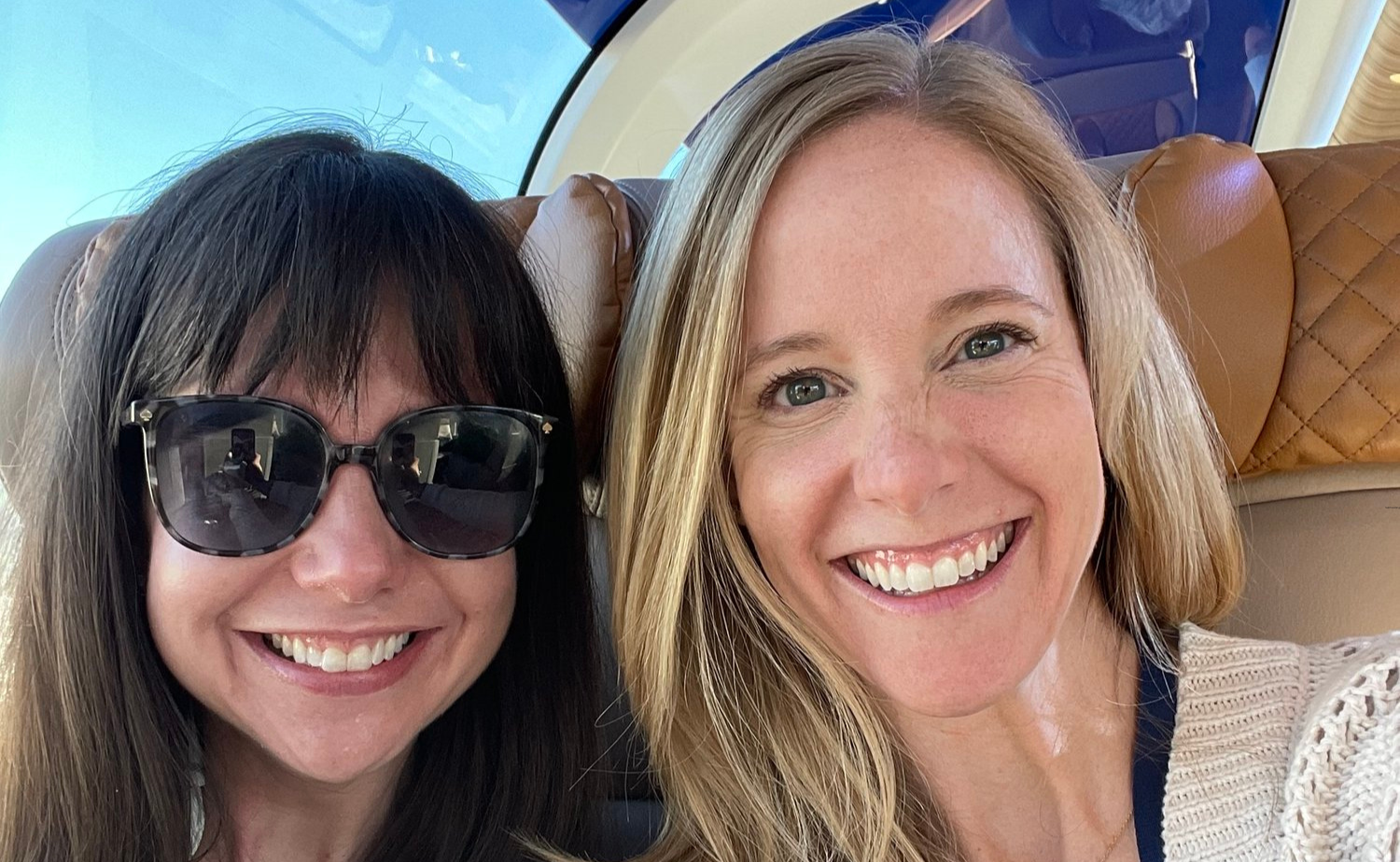 Close-up selfie of Laura and Molly aboard the Rocky Mountaineer GoldLeaf carriage with panoramic windows overhead.