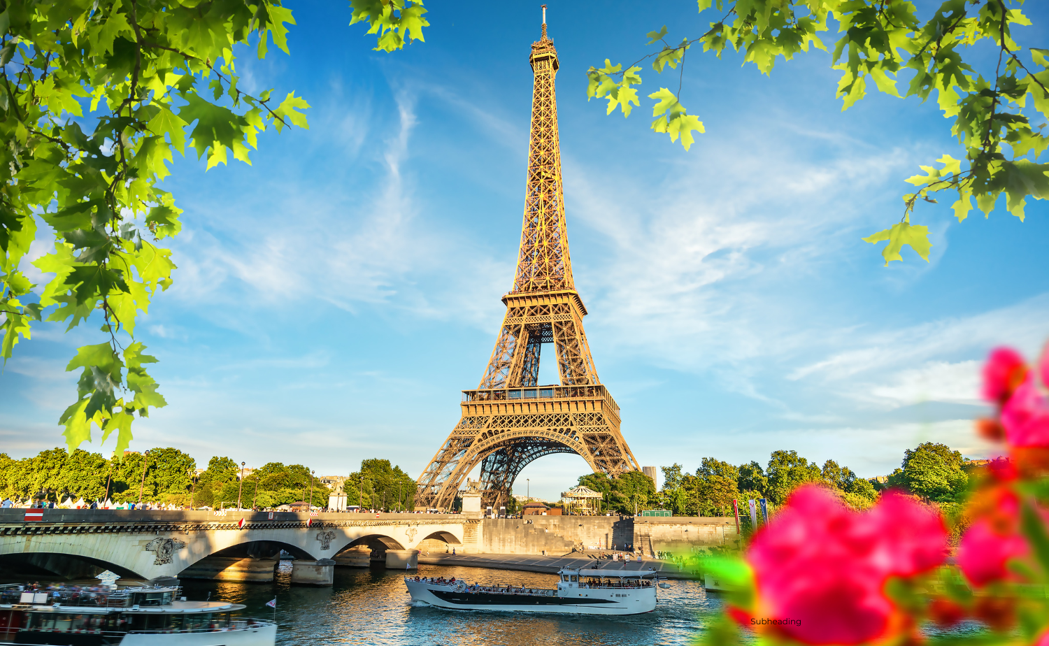 The Eiffel Tower rises above the Seine River with boats passing below and colorful flowers in the foreground.