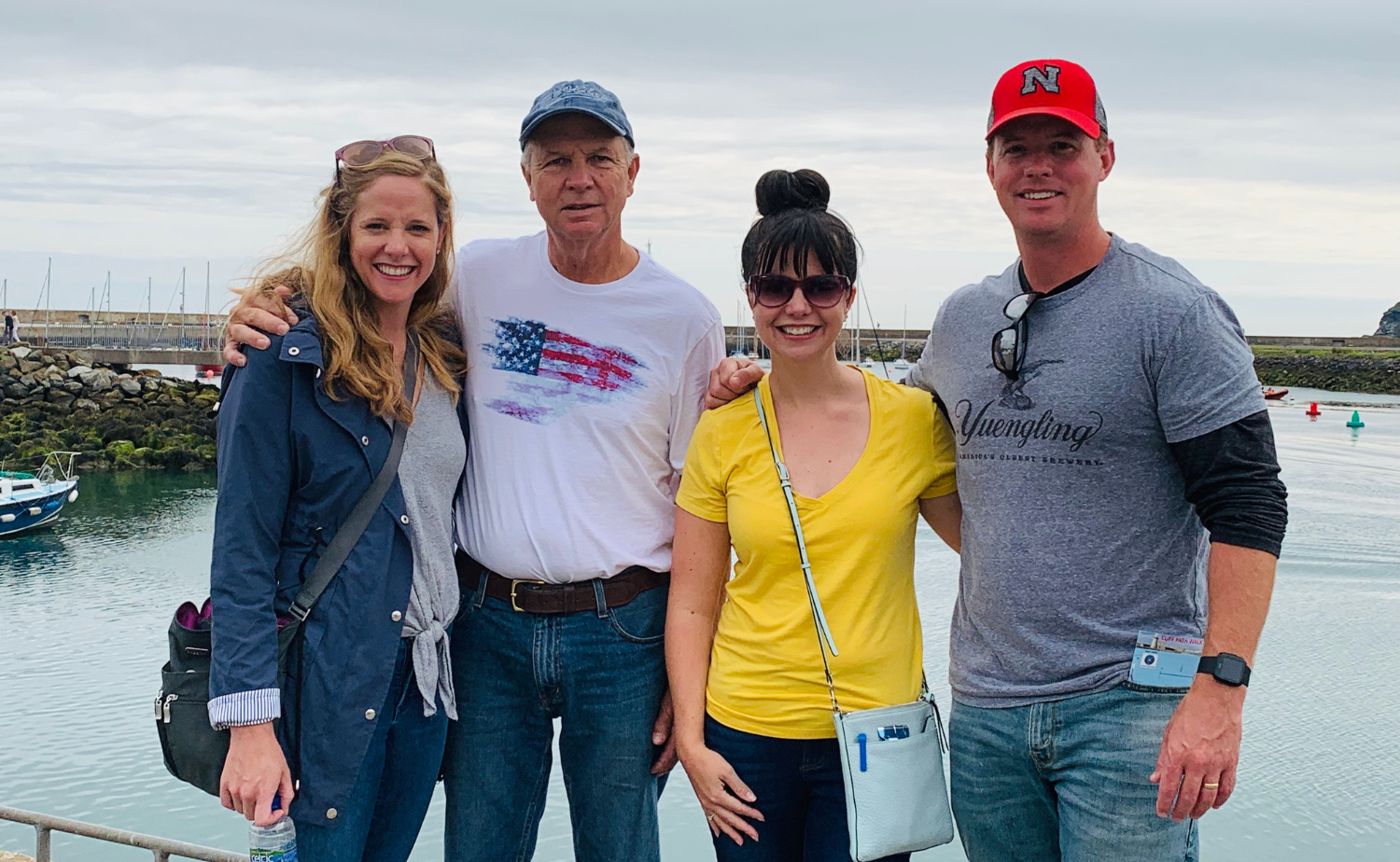 Multigenerational family standing together near a harbor while traveling in Ireland.