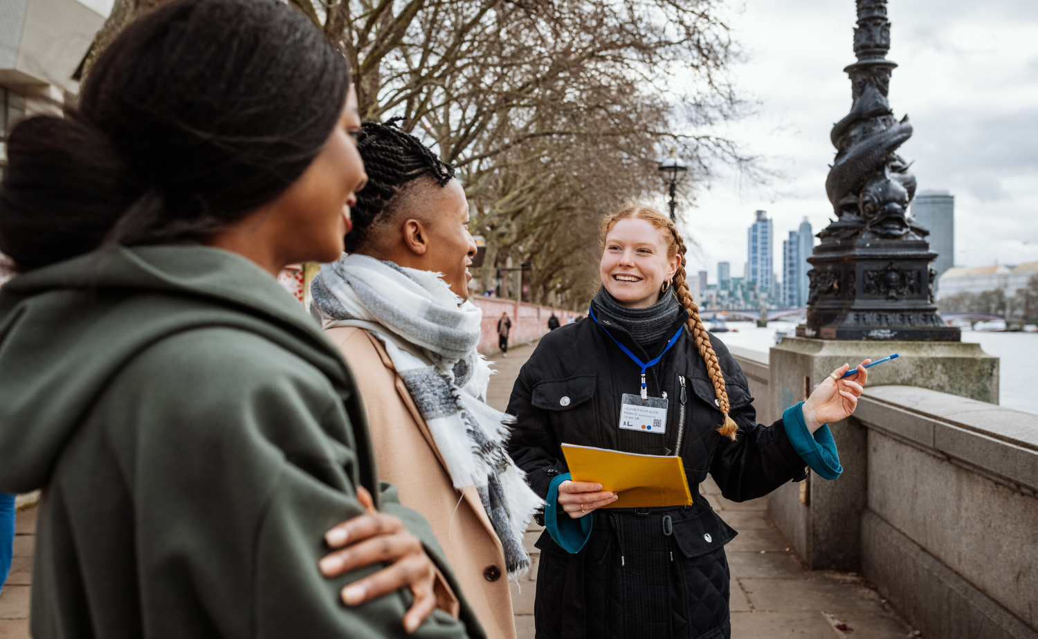 A local guide leading travelers along the Thames during a private walking tour in London.