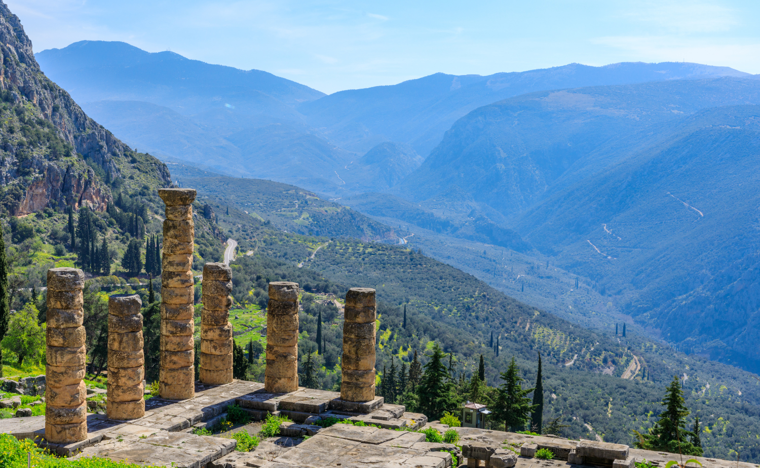 Scenic view of the ruins of the Temple of Apollo in Delphi with mountains in the background
