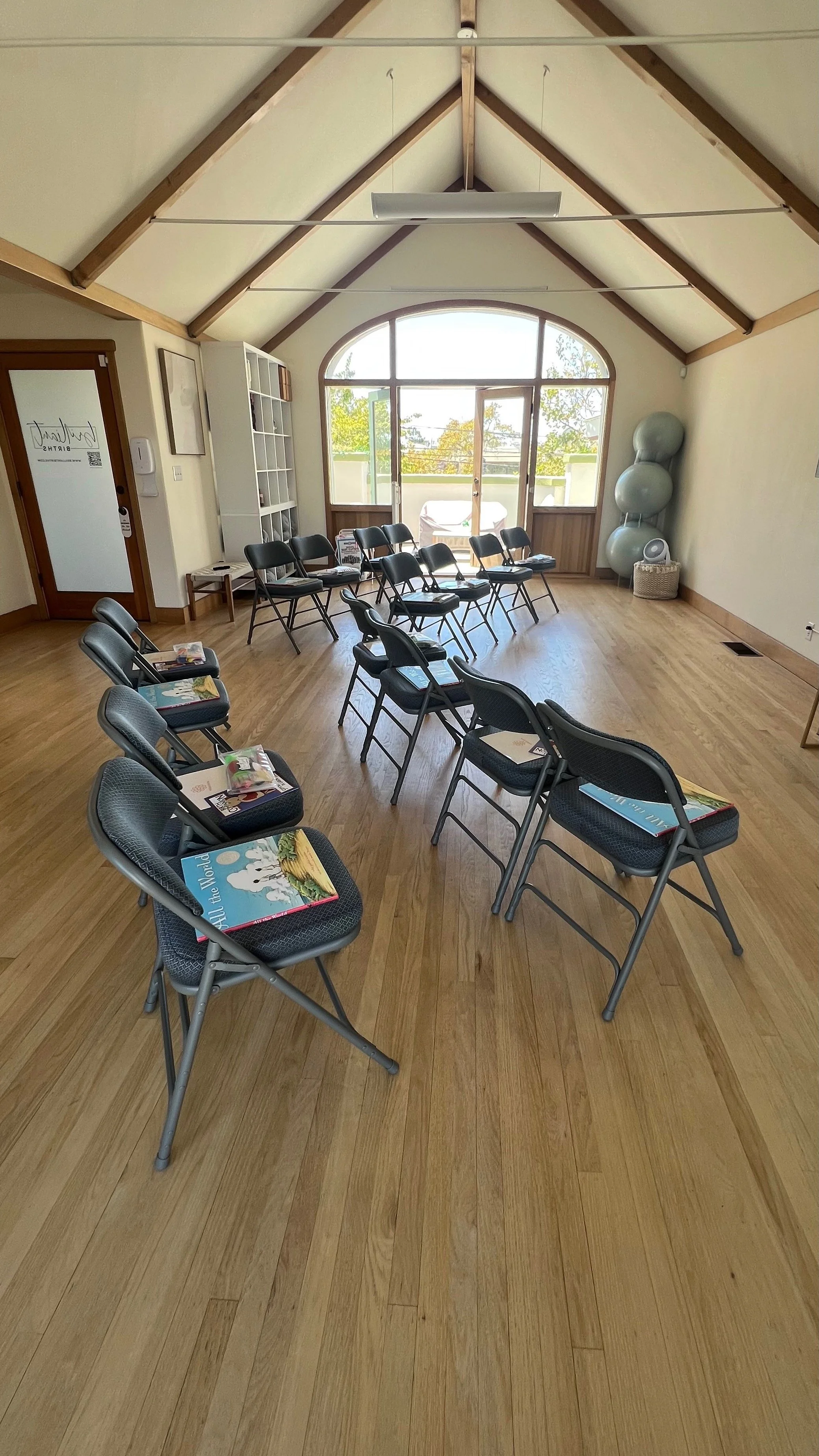 Brilliant Births' studio with chairs set out for a class. Each set of chairs has a book and an activity kit.