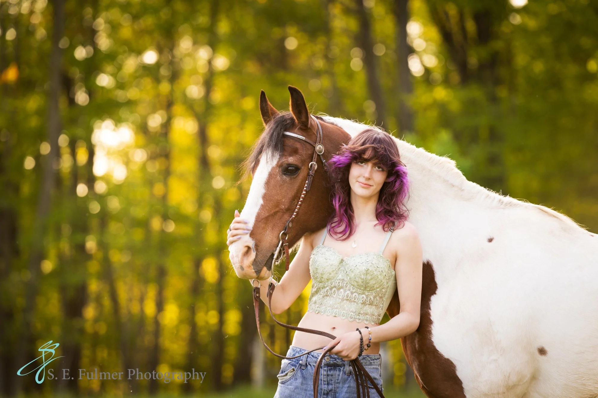 High school senior, Goodrich, MI. A woman with her horse in a forested area.
