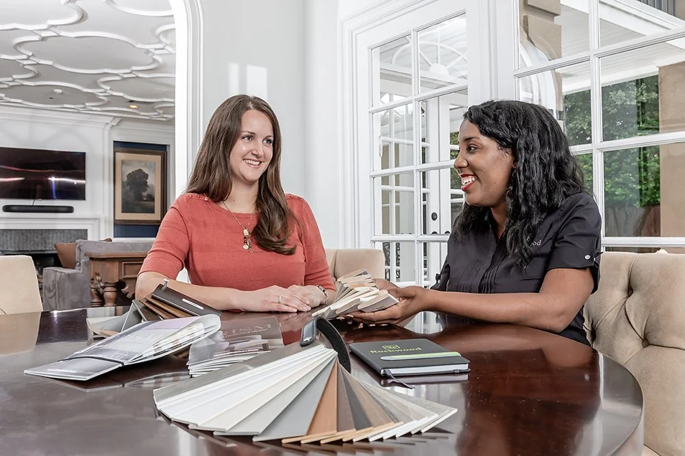 Photo of a Rockwood Shutters designer meeting with a customer in her home with window covering samples.