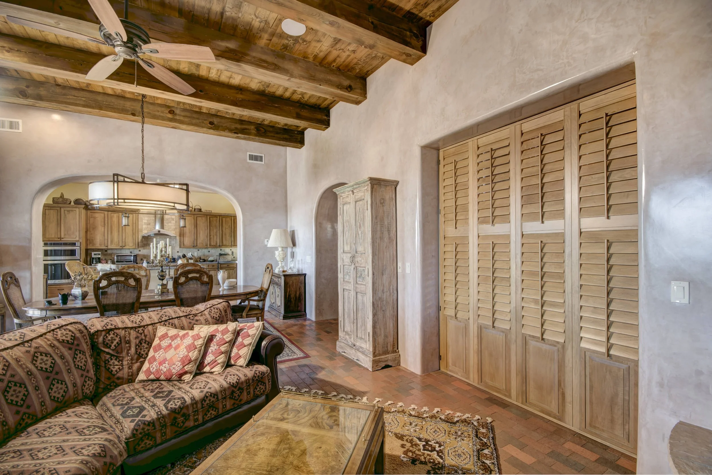 Custom Sands-stained hardwood shutters installed within doorway opening in a Santa Fe home.