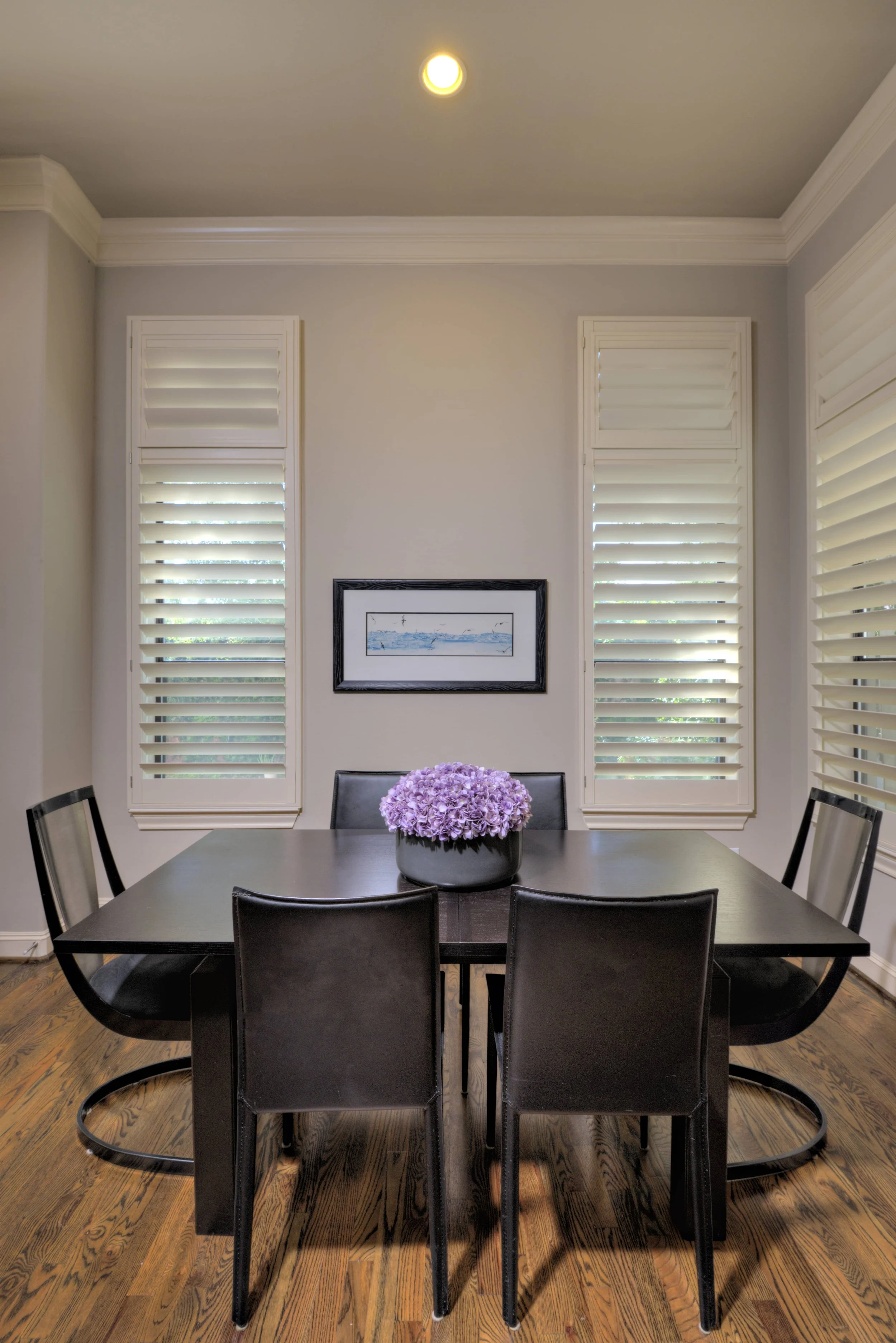 White plantation shutters with ClearLine tilt on tall dining room windows in a Chicago-area home.