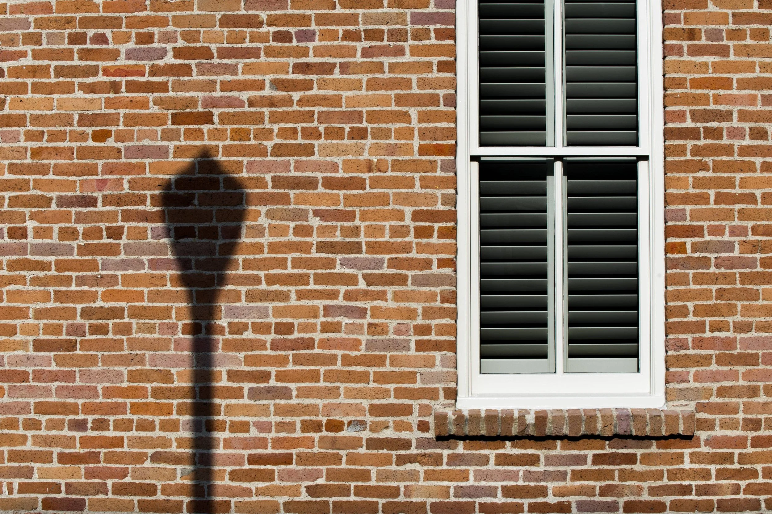 Custom shutters seen from the exterior of a brick firehouse in St. Louis.