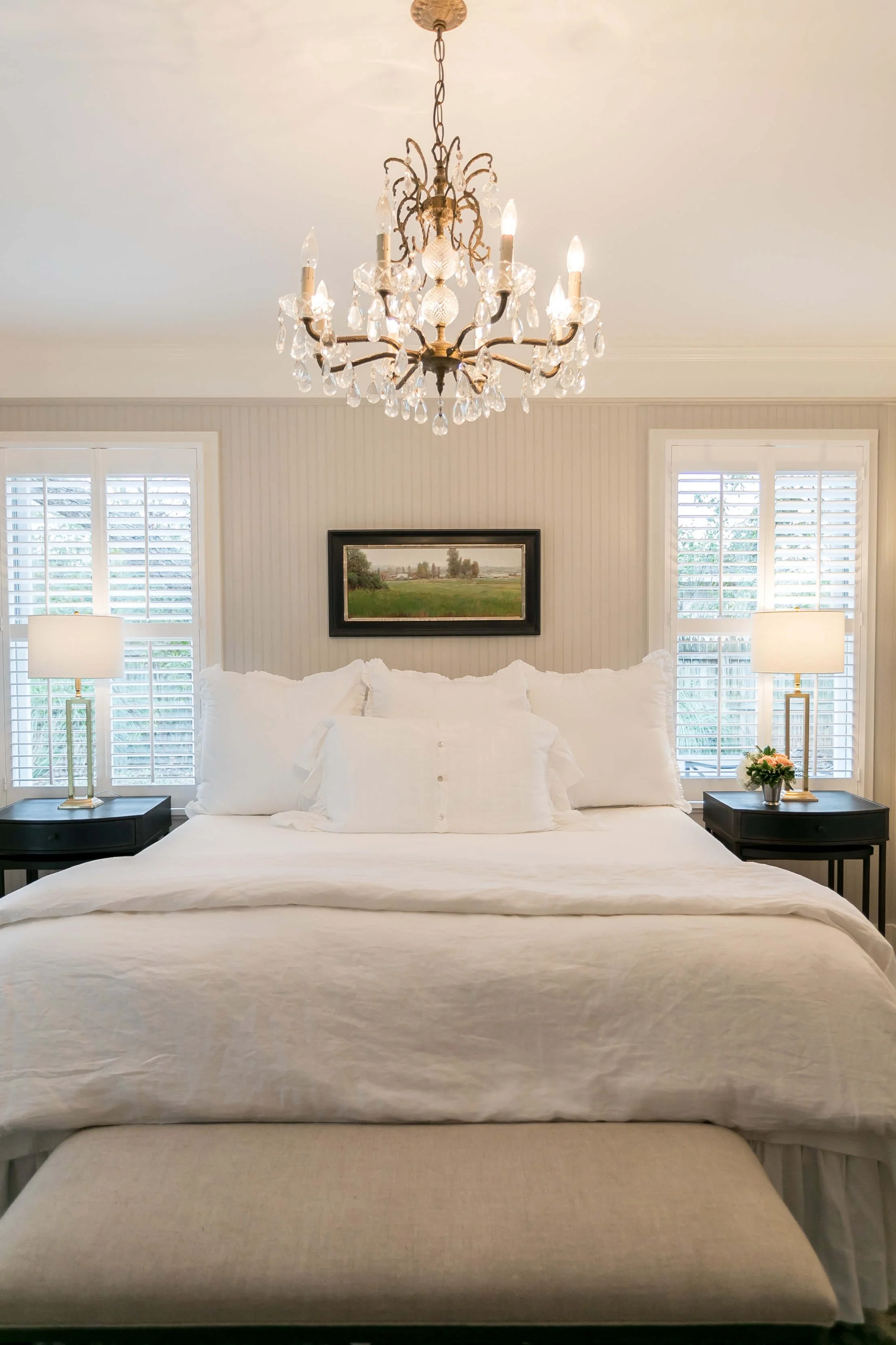 Rockwood plantation shutters framing a bright guest bedroom at Bella Regalo in Fredericksburg, Texas