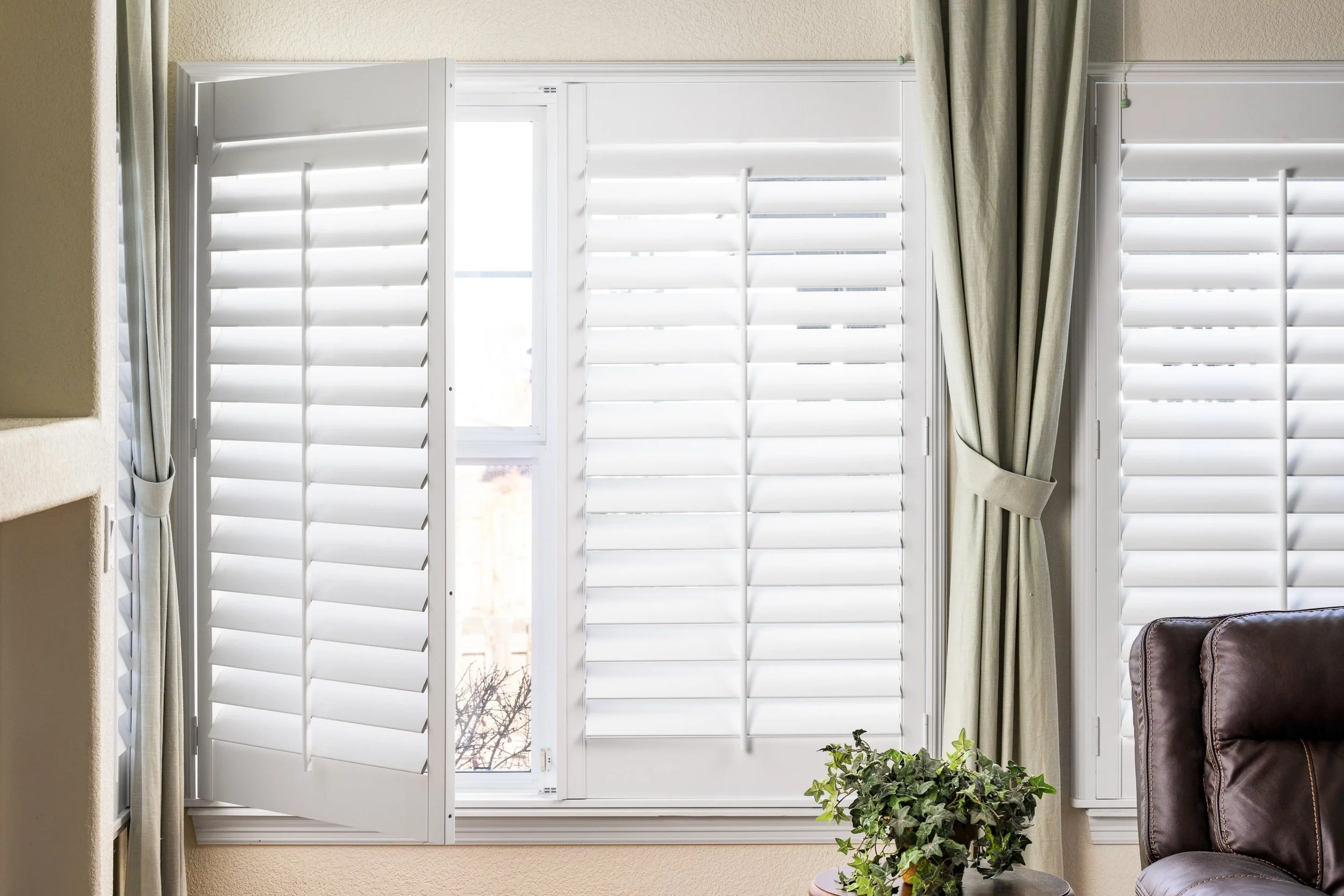 Hinged bright white plantation shutters in the living room of the Colorado Classic home.