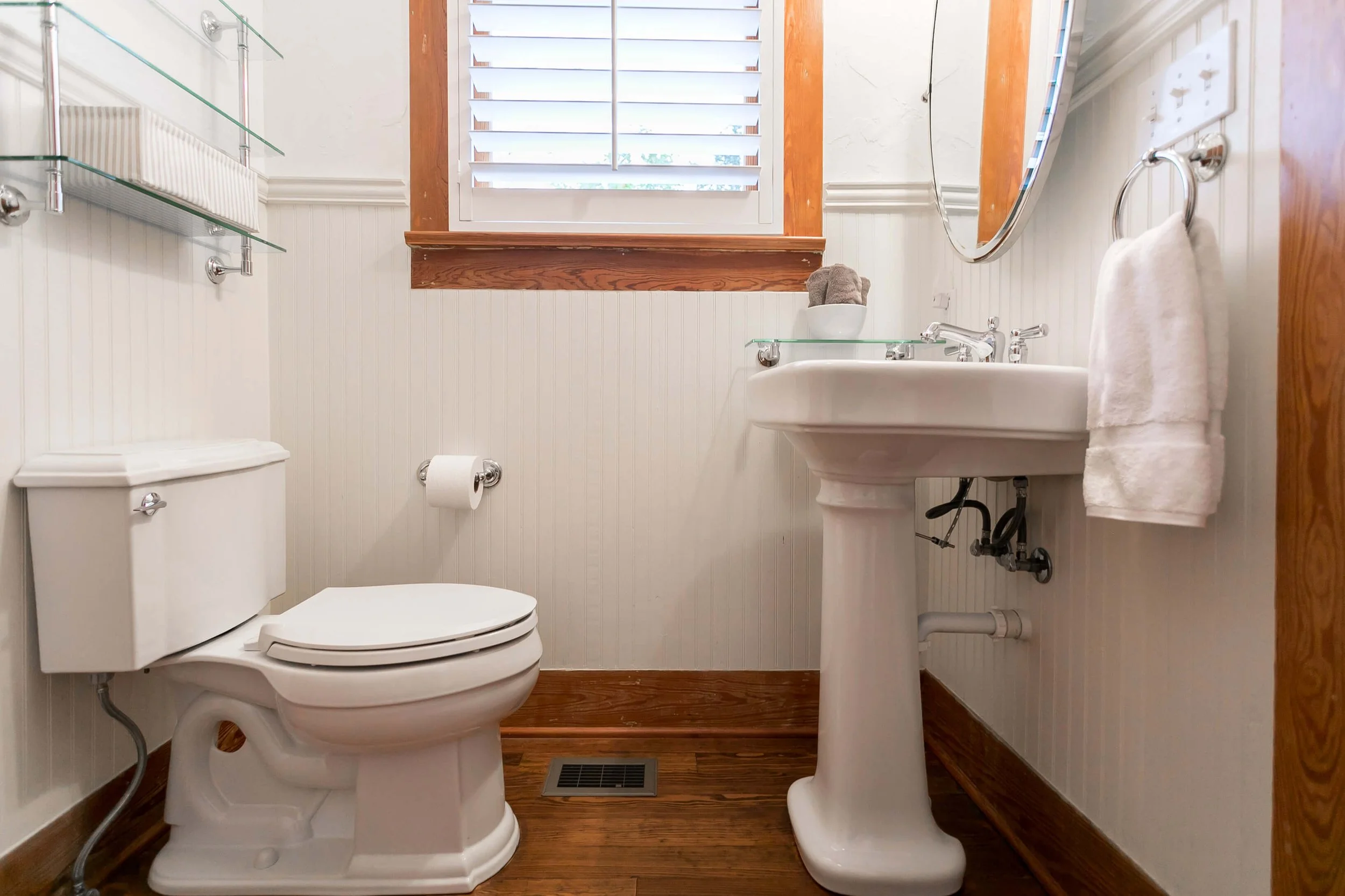White plantation shutters above a pedestal sink in a Fredericksburg, Texas vacation rental
