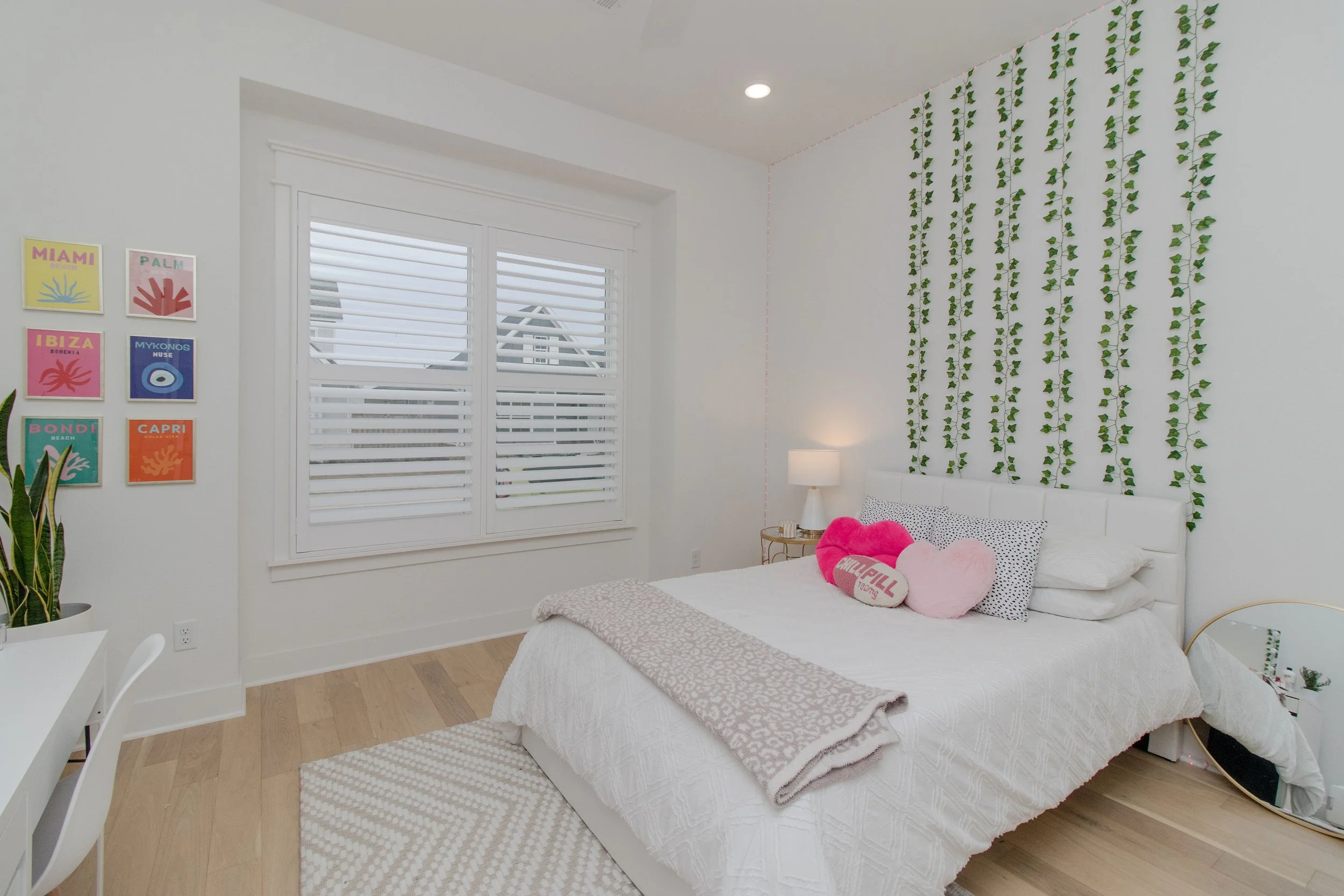 Bright white plantation shutters on a double bedroom window in a Northwest Arkansas home.