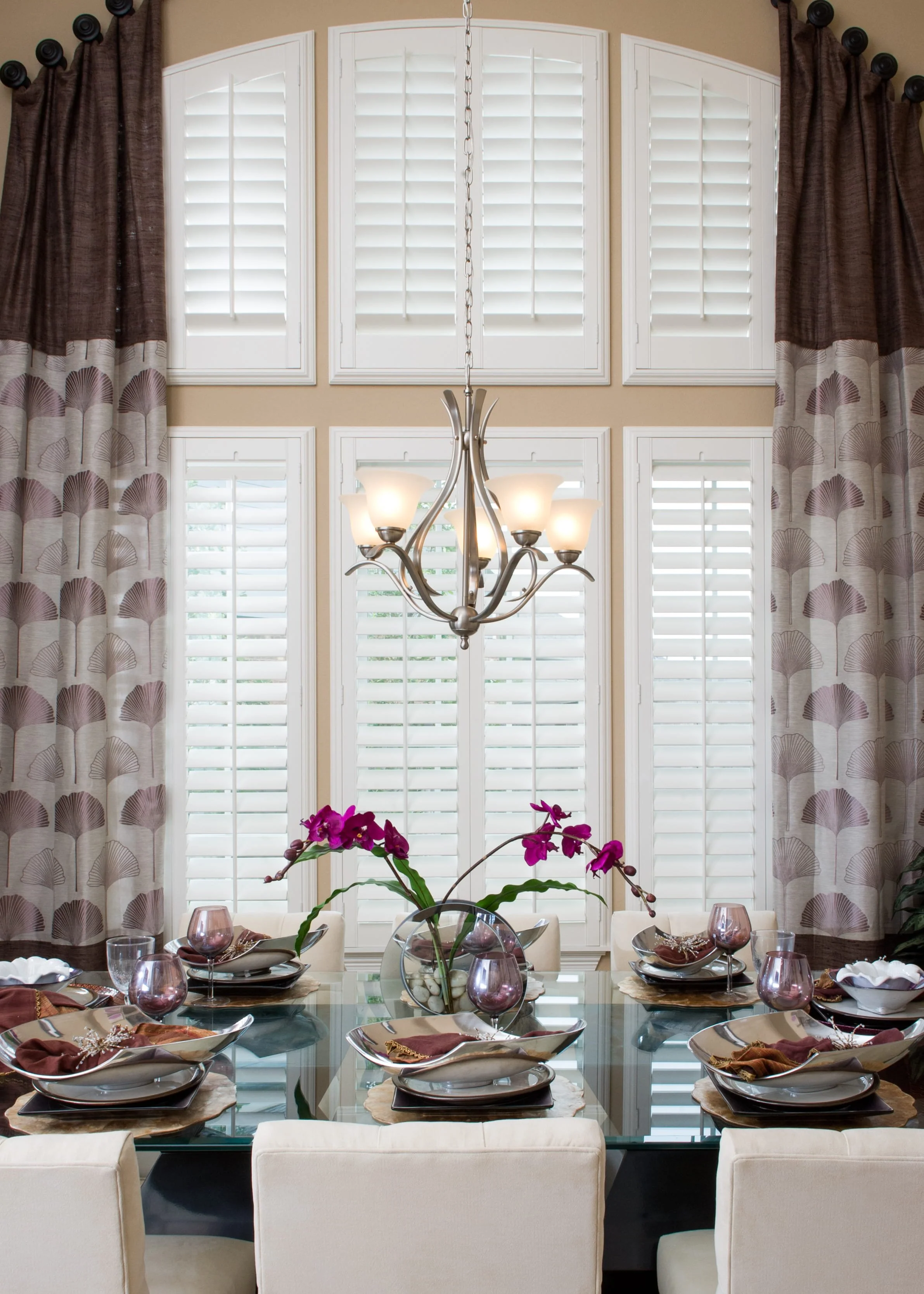 Arched window with Rockwood shutters combined with drapery in a Sugarland, TX home.