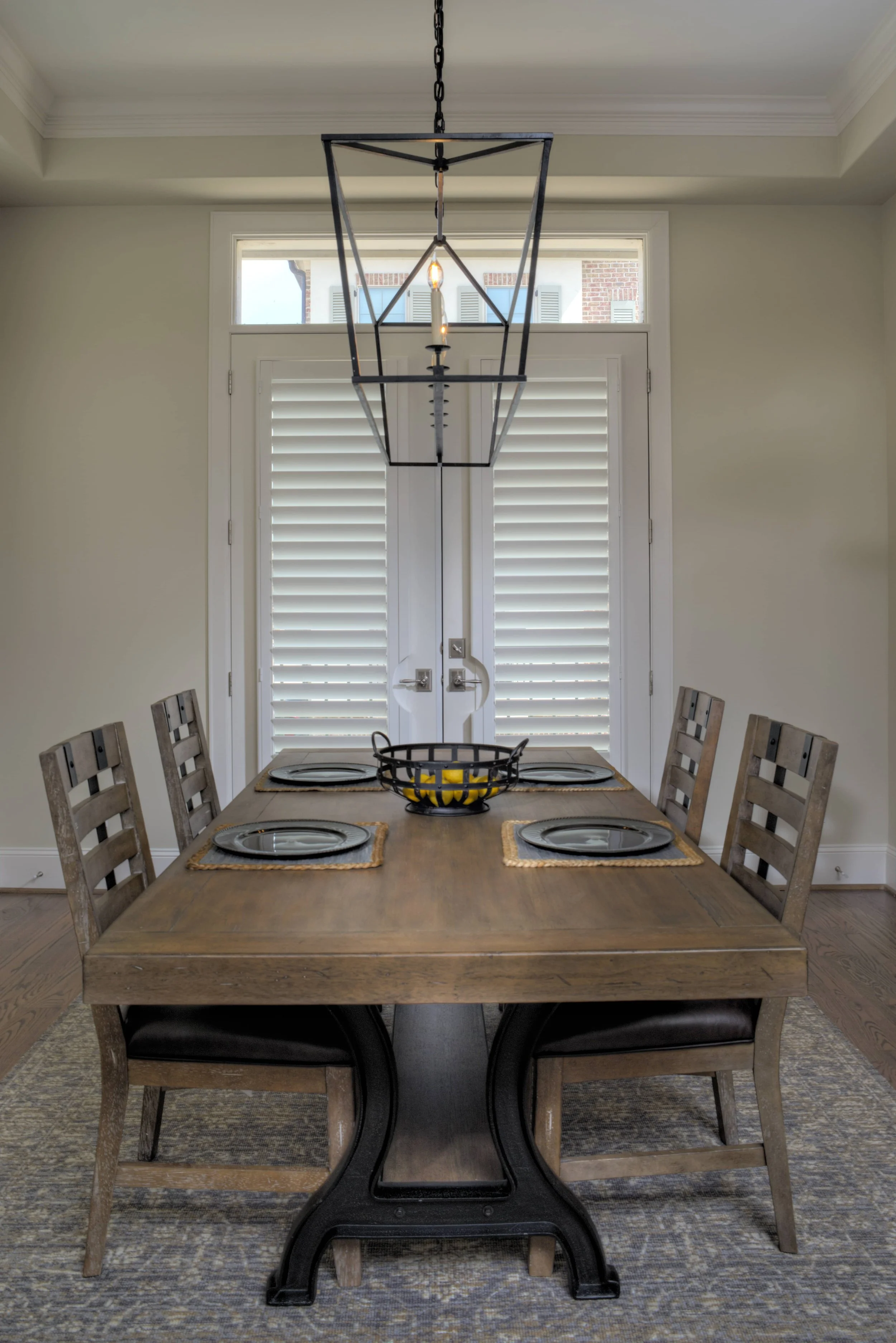 Custom white French door shutters with ClearLine tilt in a dining room in The Woodlands, Texas.