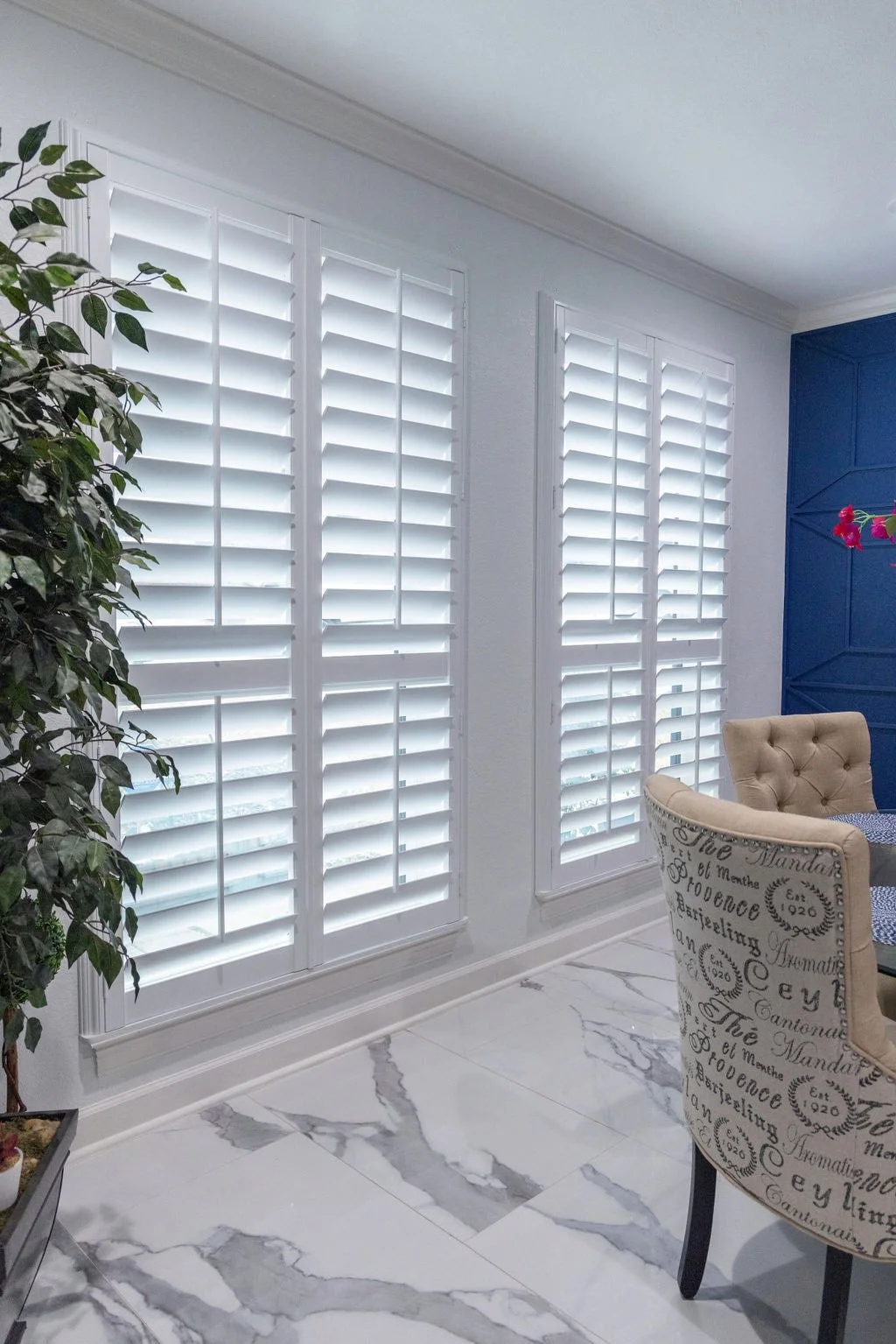 Modern breakfast room in Dallas urban home featuring wide windows with plantation shutters.