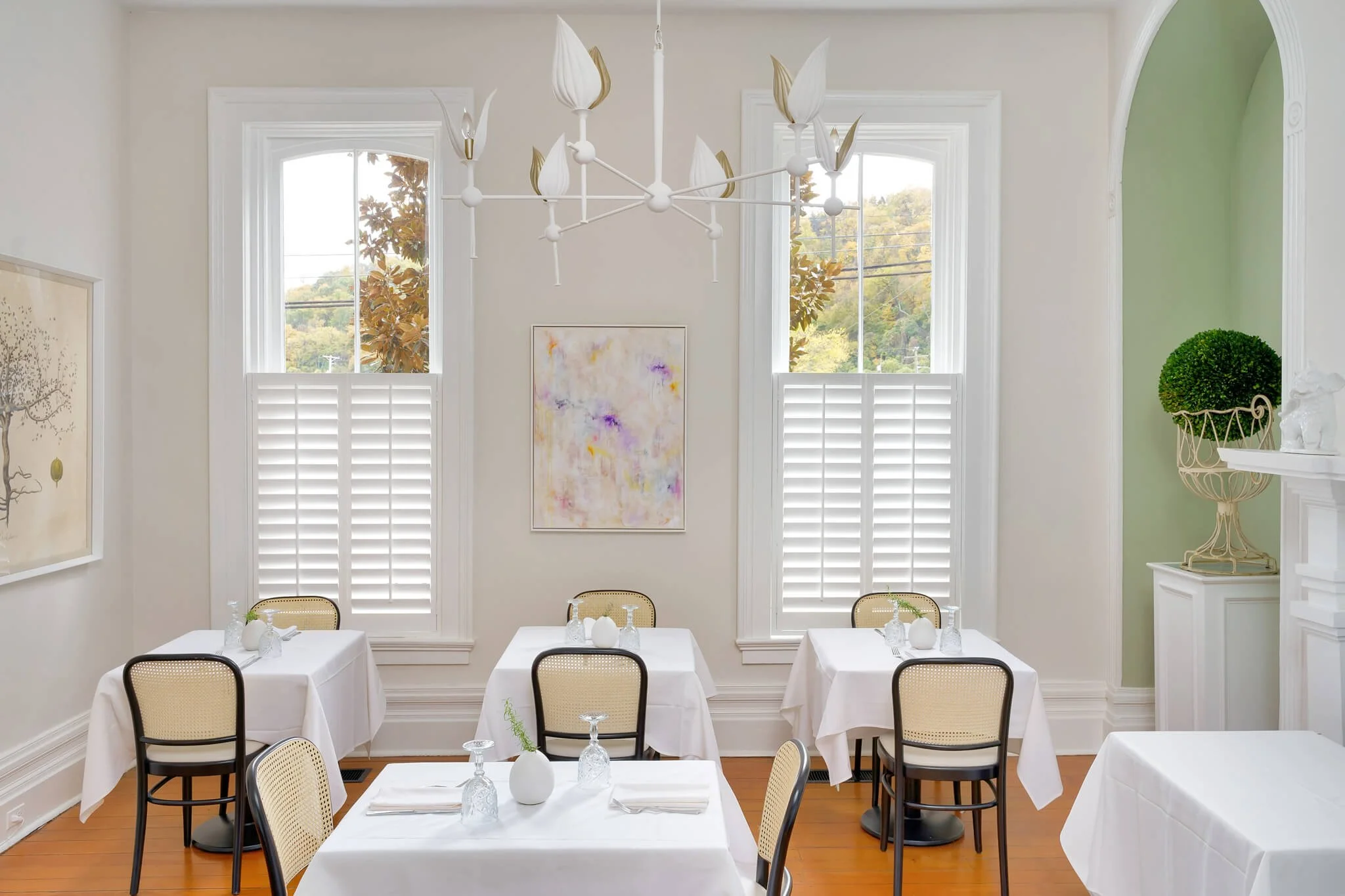White LiteLine café-style shutters on a tall arched window at Limewater Bistro in Frankfort, Kentucky.