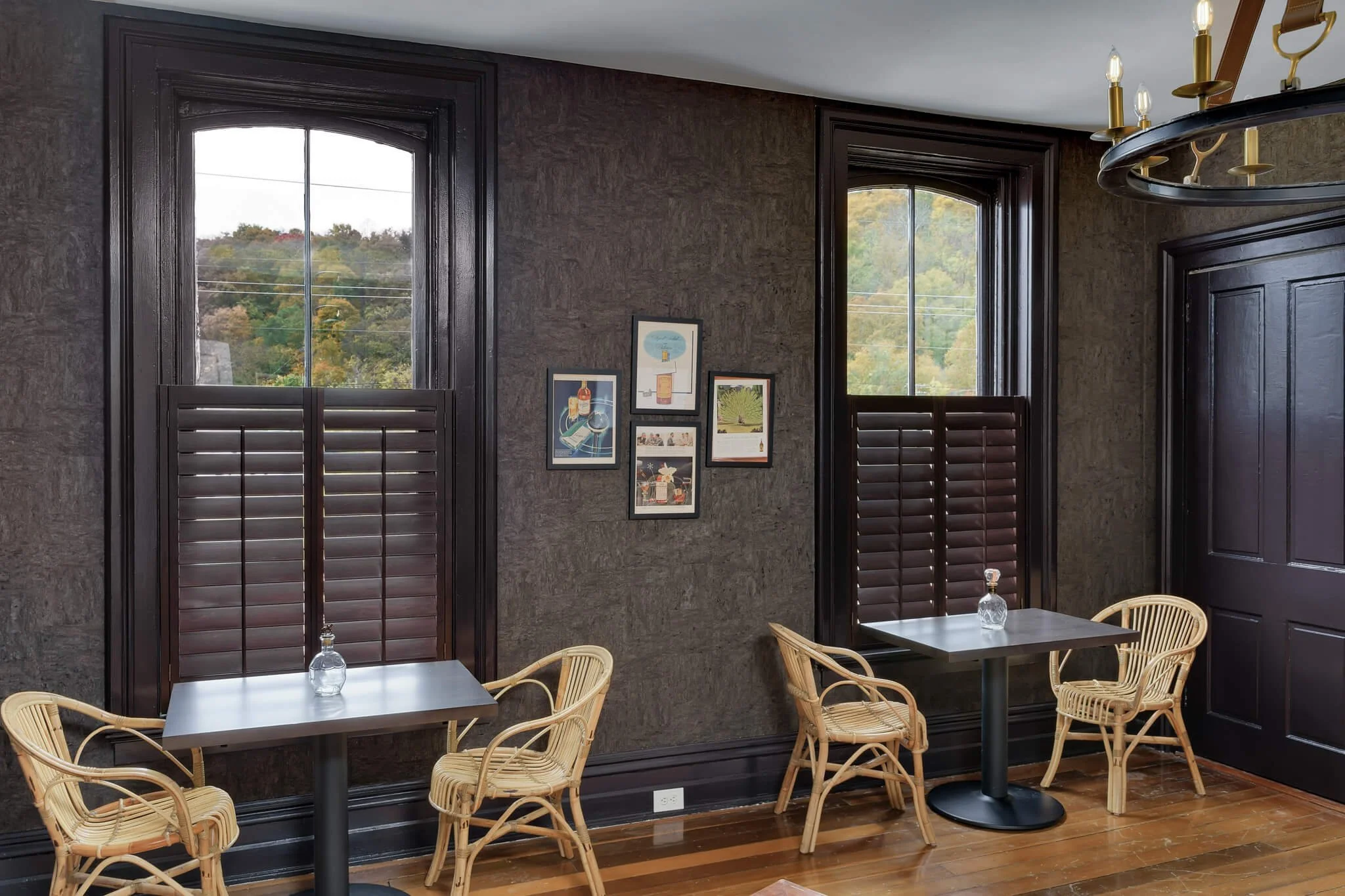 Dark wood café-style shutters on tall windows in a dining room at Limewater Bistro in Frankfort, KY.