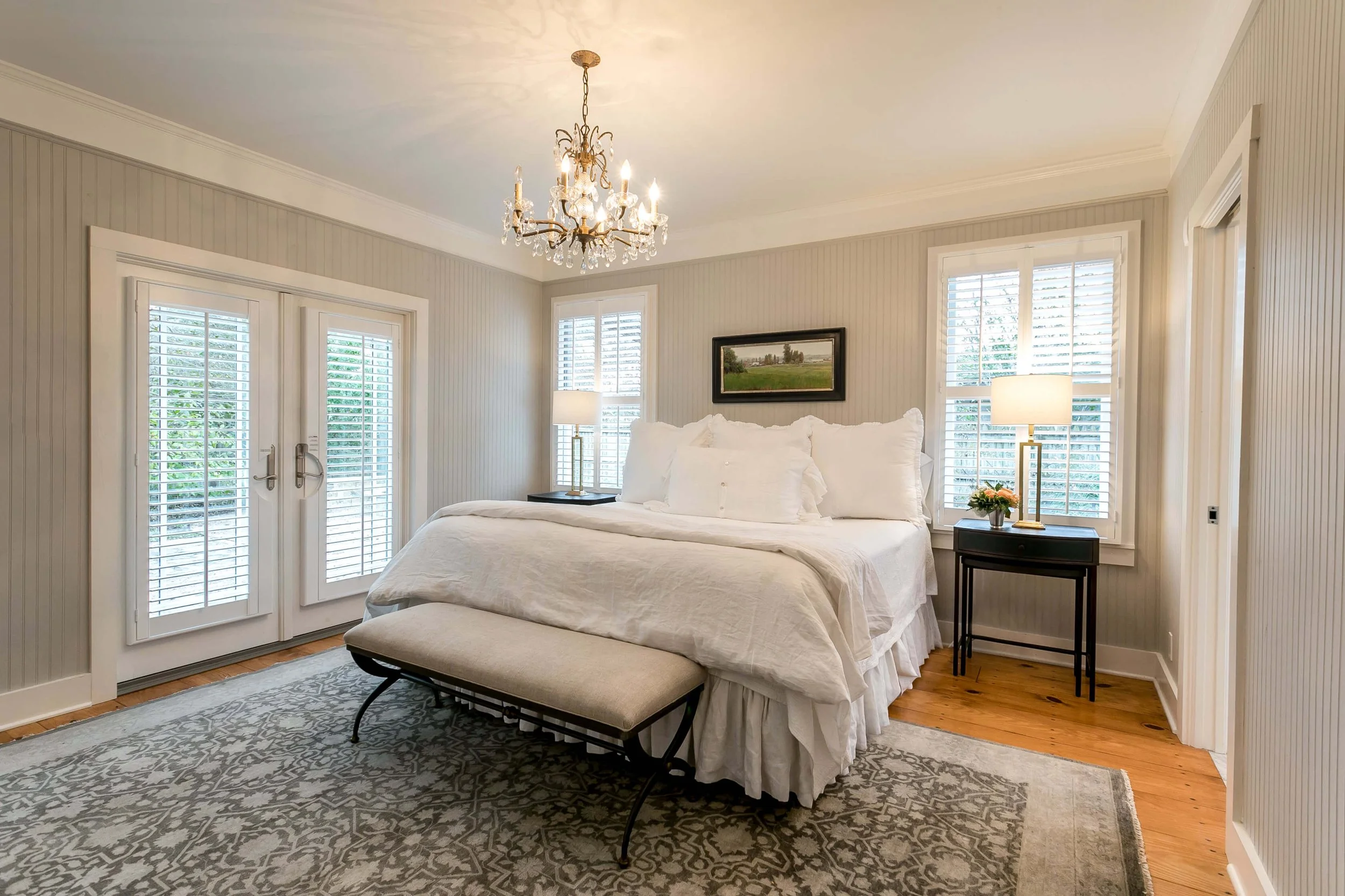 White plantation shutters on bedroom windows and French doors at Bella Regalo in Fredericksburg, Texas