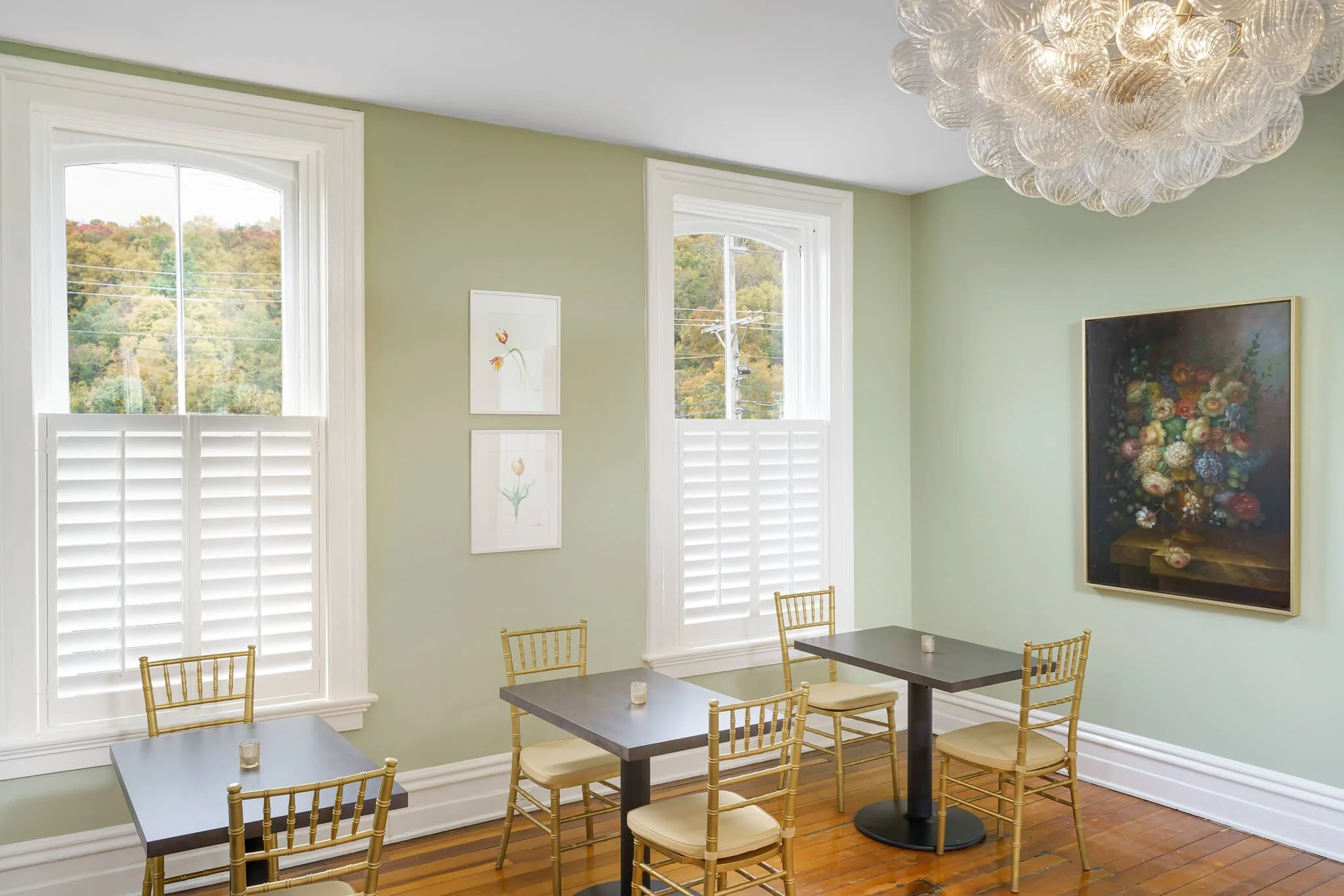 White café-style shutters on tall windows in a dining area at Limewater Bistro in Frankfort, KY.