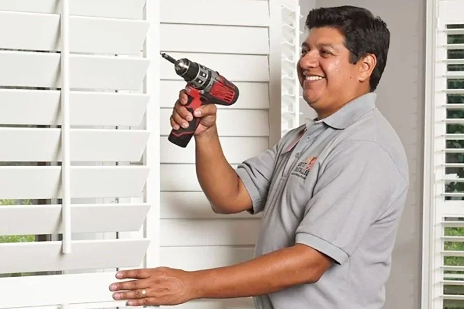 Photo of a Rockwood Shutters technician completing the installation of custom shutters.