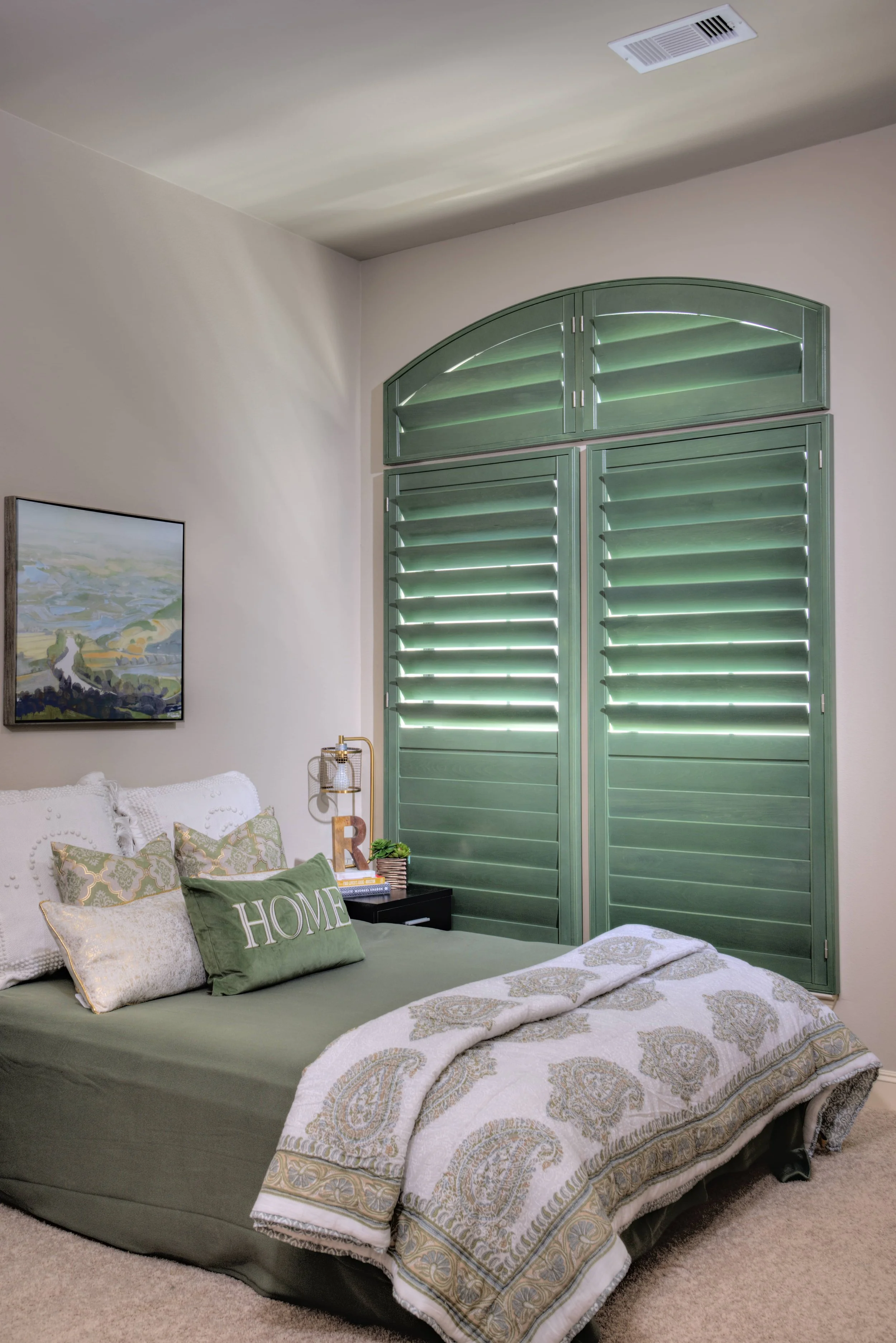 Custom green stained shutters with ClearLine tilt and an arched top in a Chicago-area bedroom.