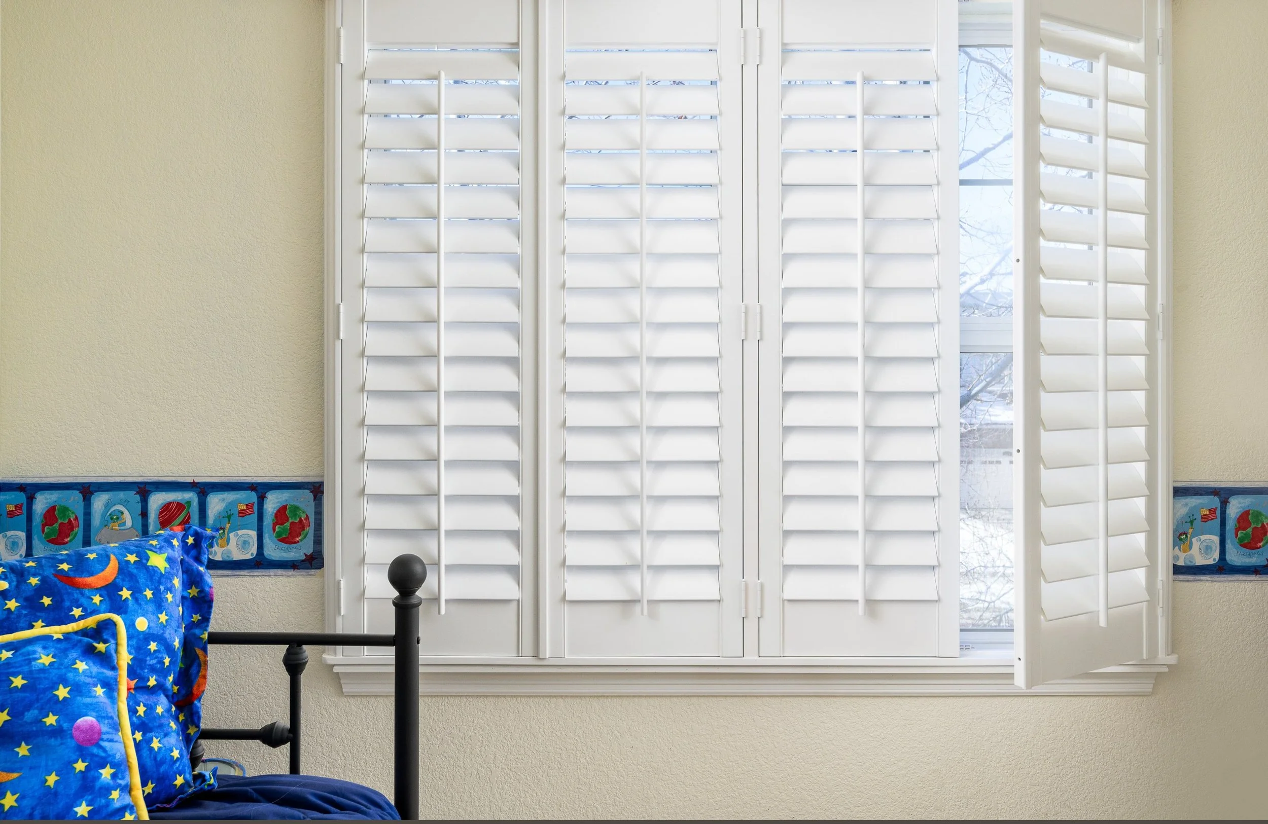Bright white plantation shutters in a child's bedroom.