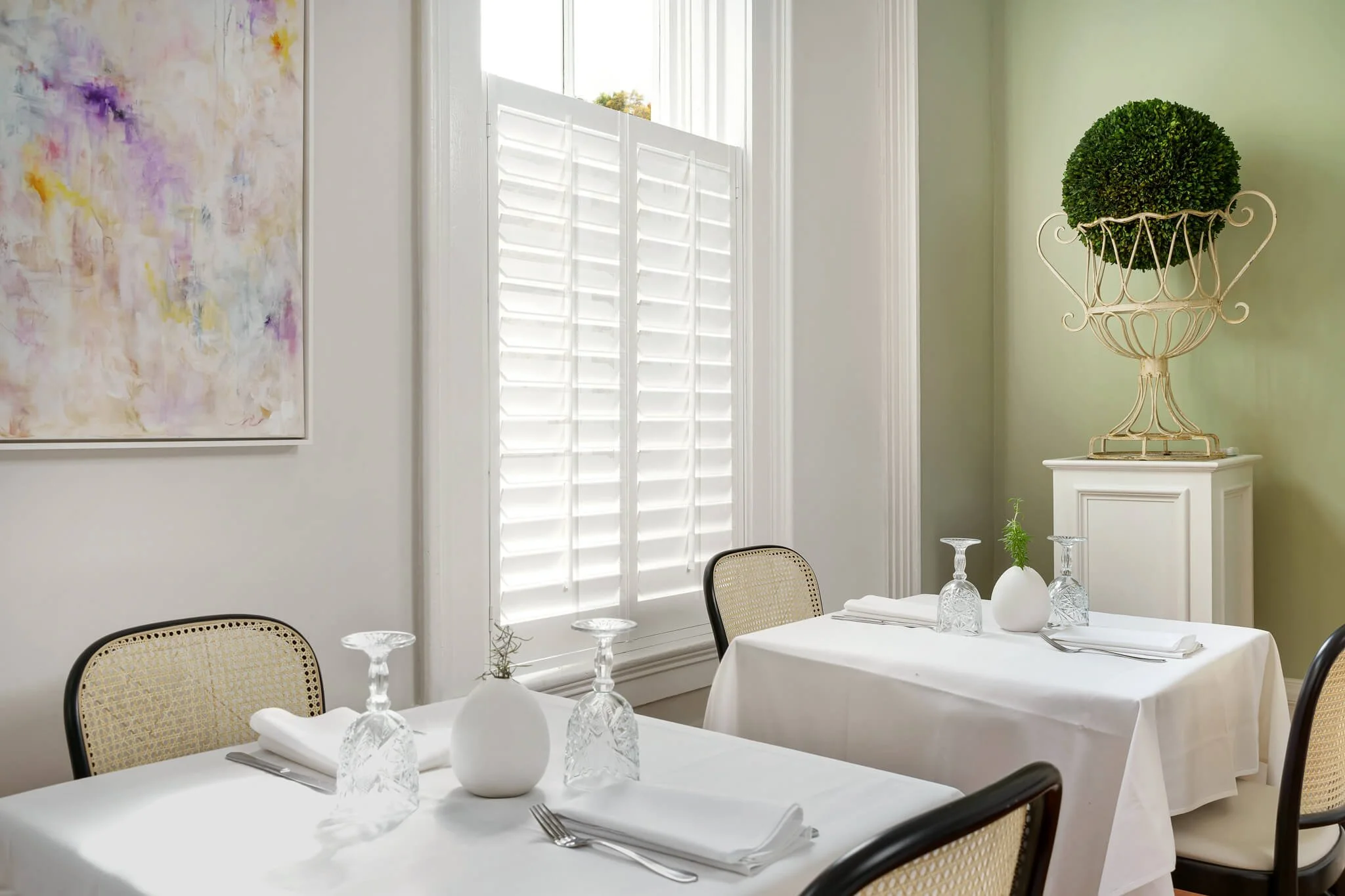 Wide view of the Limewater Bistro bar featuring white café-style shutters on tall windows.