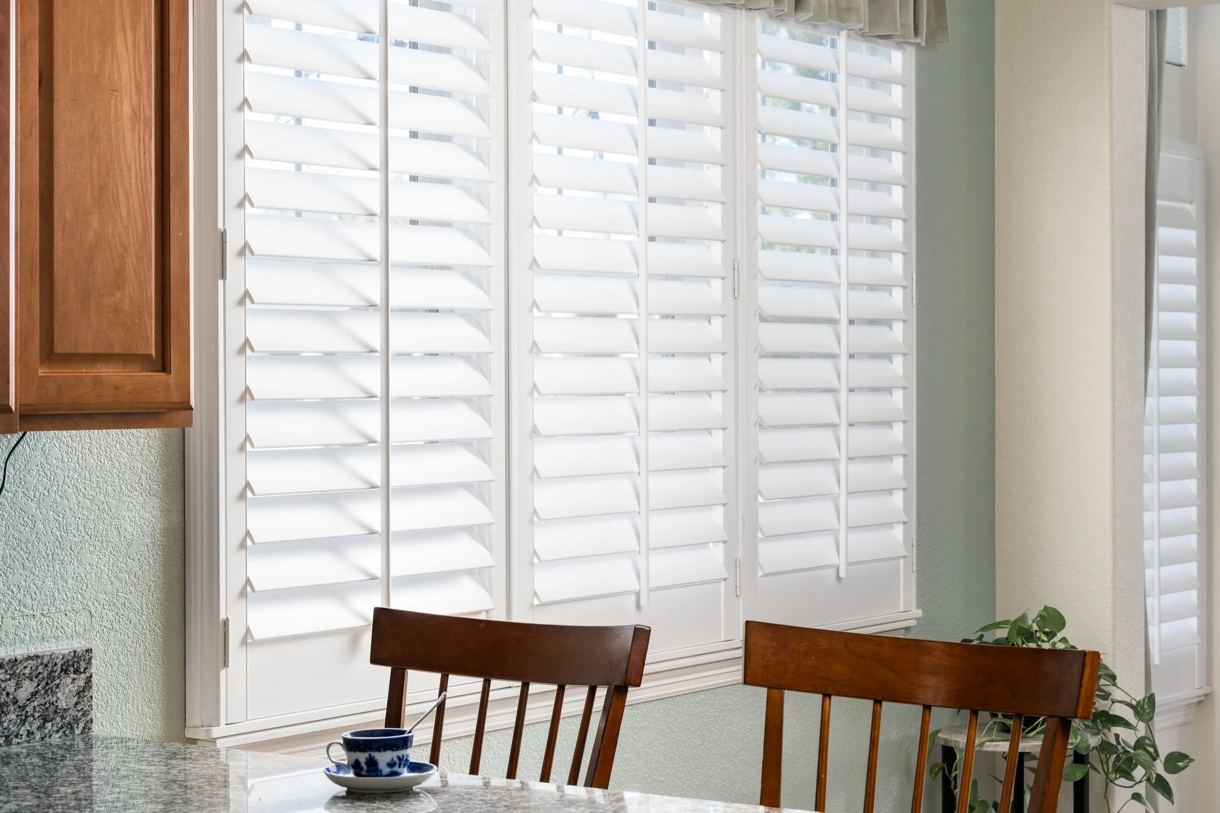 Plantation shutters along the dining room windows in the Colorado Classic residence.