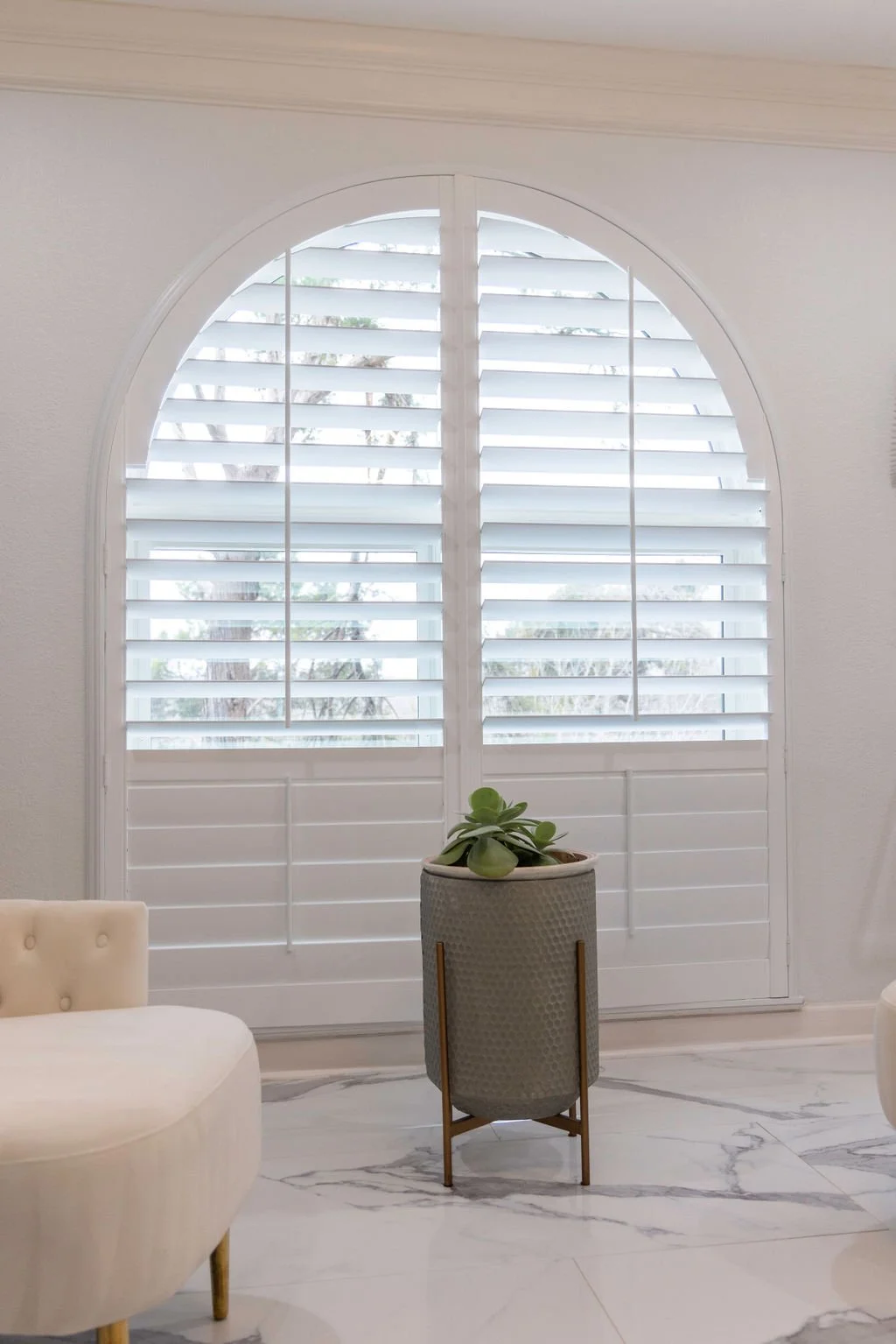 Rockwood's Grand Arch shutters on a window in an urban Dallas home.  The top portion of the shutters are open and the bottom portion closed.