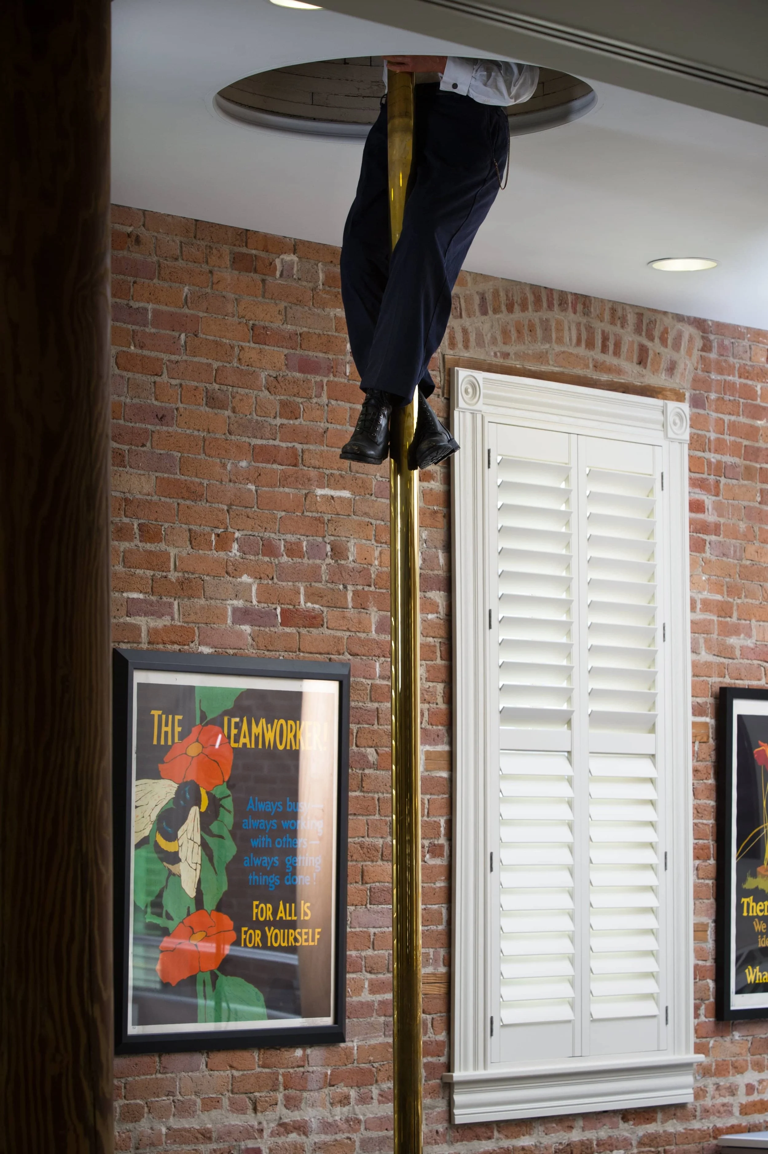 Custom white shutters with ClearLine tilt complement the exposed brick architecture of a St. Louis firehouse.