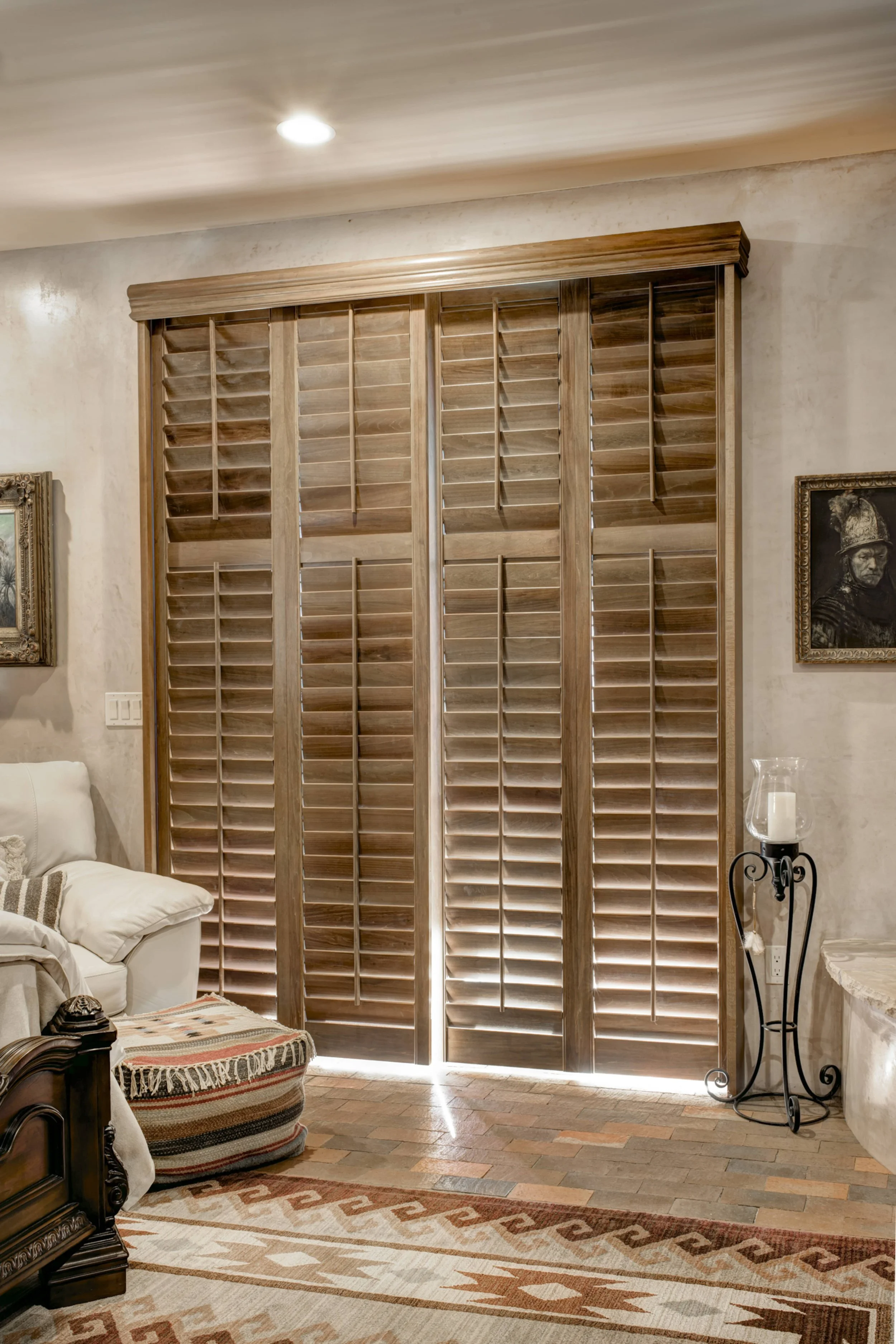 Sands-stained hardwood shutters covering a sliding glass door in a Santa Fe, New Mexico bedroom.