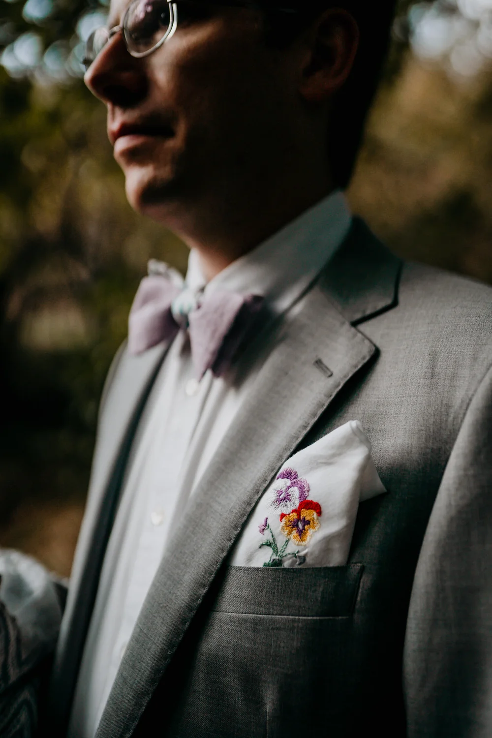 Groom wearing an embroidered heirloom handkerchief in the pocket of his grey suit