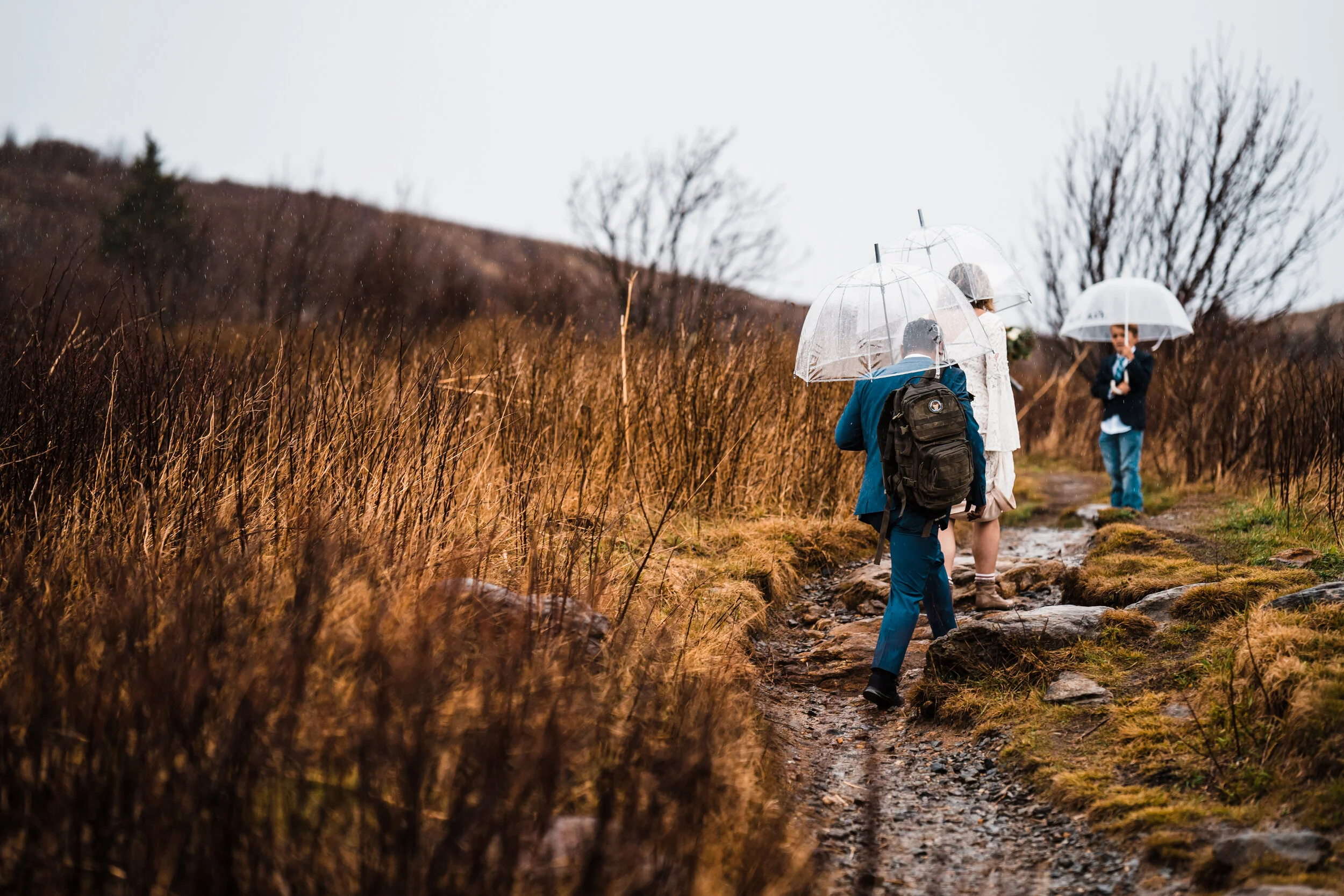 Couple hiking with clear umbrellas during light rain in the mountains of western North Carolina