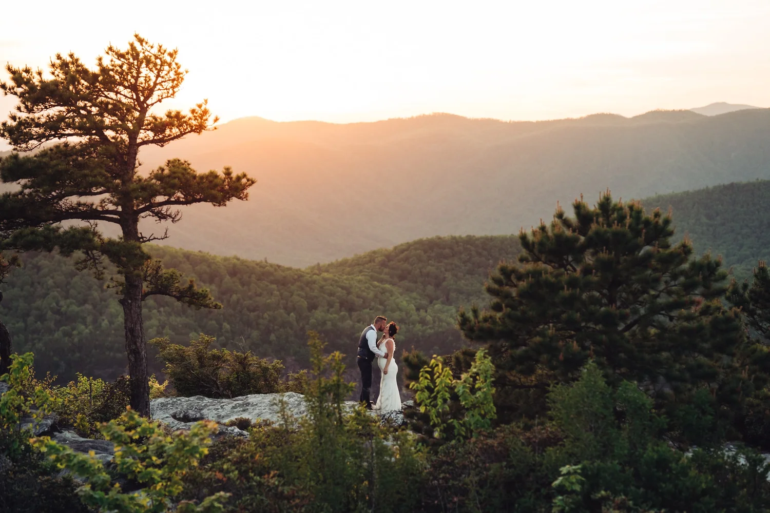 Andrea and Adam standing together above the Blue Ridge Mountains near sunset