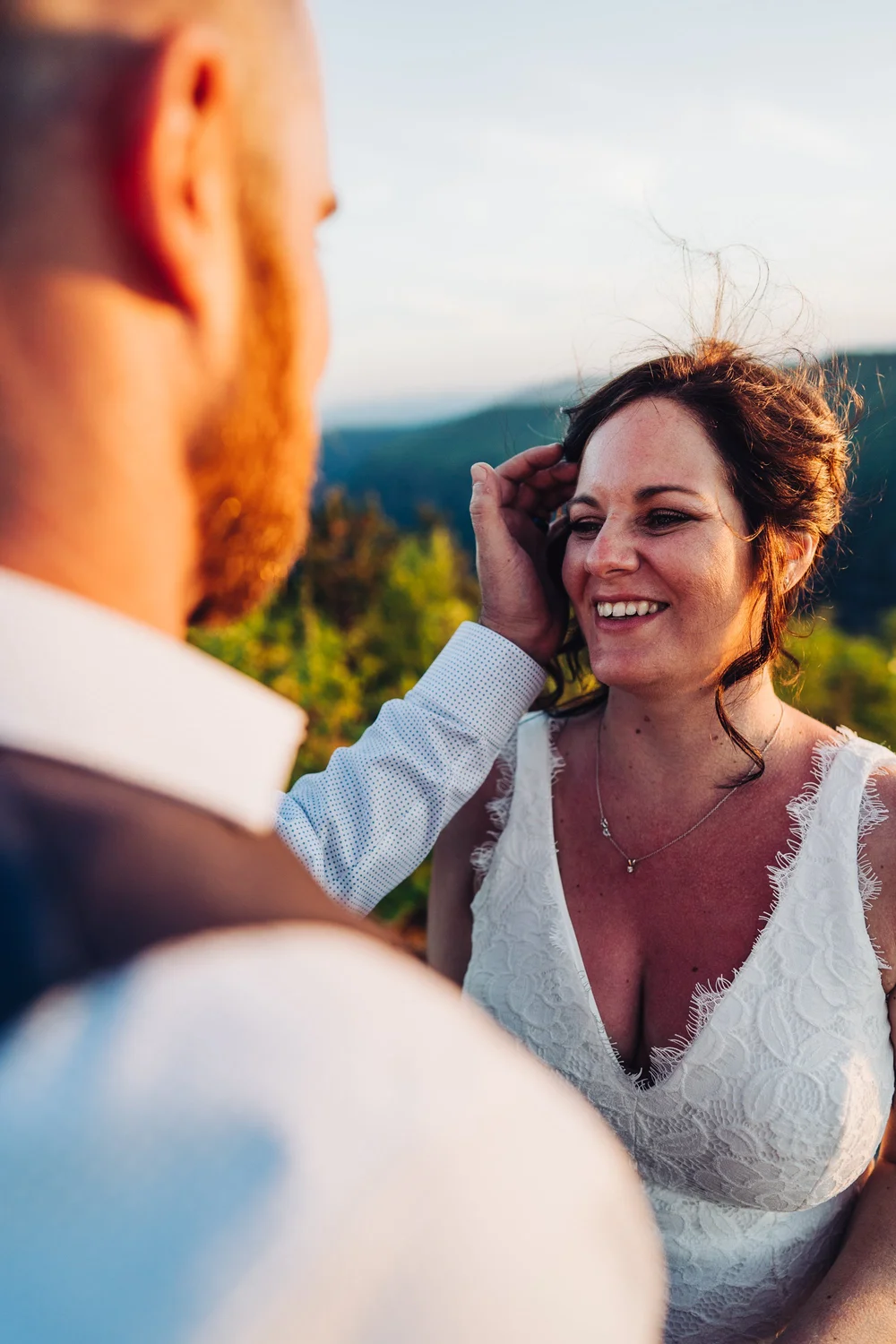 Adam brushes Andrea's hair away from her face during their mountain elopement